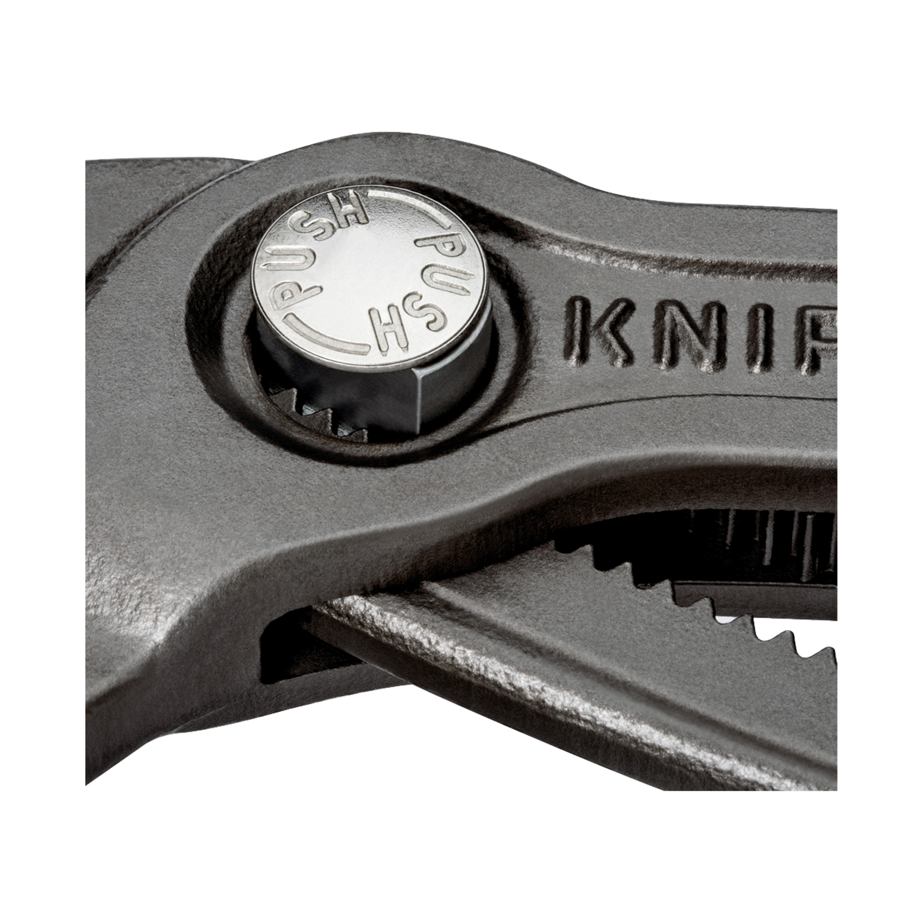 Zbliżenie czarnego klucza nastawnego. Widoczny jest srebrny, okrągły przycisk z napisem 'PUSH' i 'HS'.