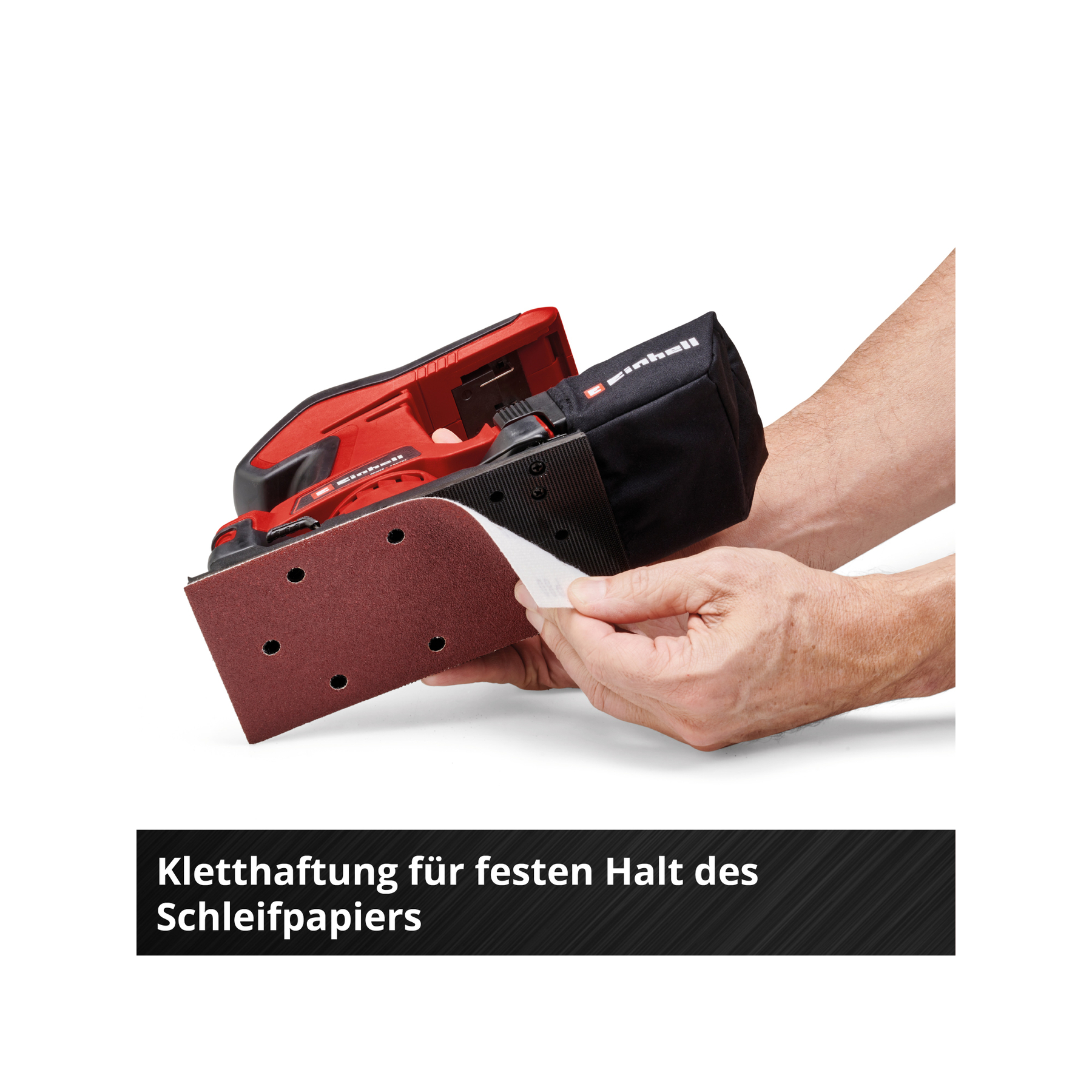 Czerwona szlifierka elektryczna z czarnym workiem na pył trzymana przez osobę. Do podkładki szlifierki mocowany jest papier ścierny.