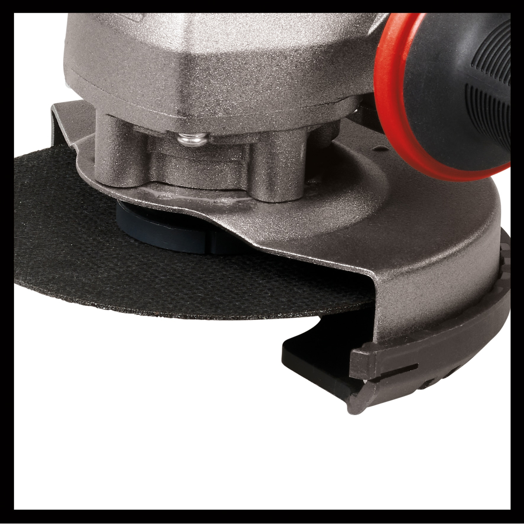 Zbliżenie szlifierki kątowej. Szlifierka jest szara z czarną tarczą szlifierską. Ma czerwono-czarny uchwyt.