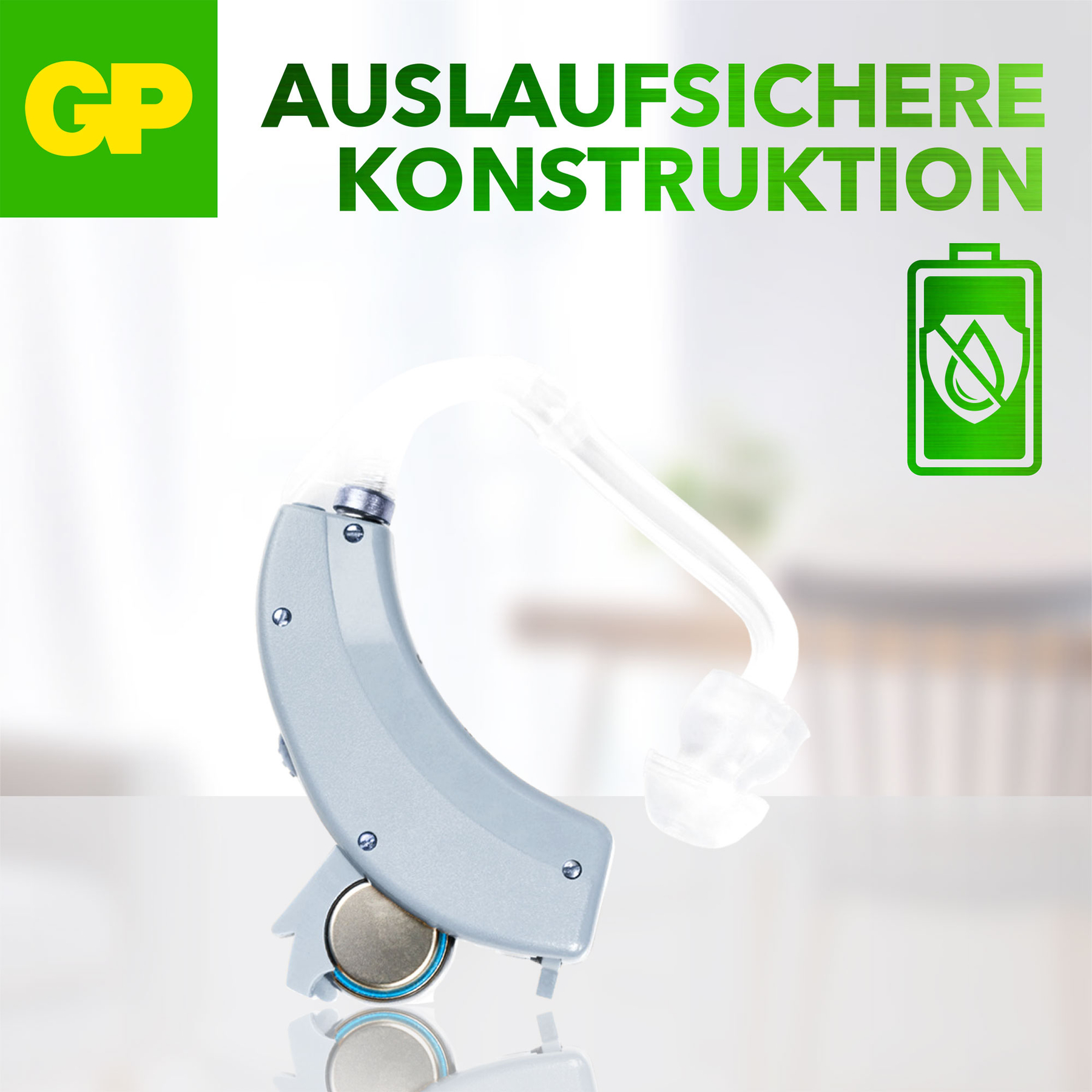 Un apparecchio acustico con batteria e un tubo con auricolare. Testo in tedesco: AUSLAUFSICHERE KONSTRUKTION. Logo GP.