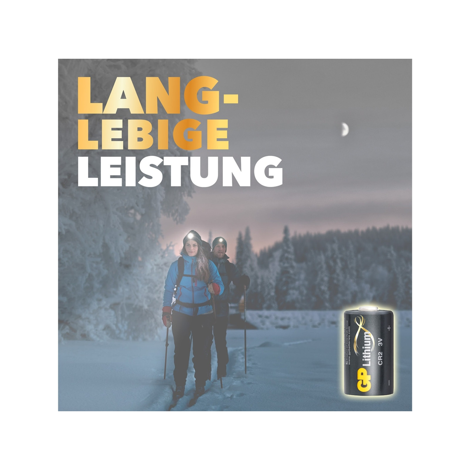 Zwei Personen, die bei Dämmerung in verschneiter Landschaft Ski fahren, mit Stirnlampen. Eine Batterie ist im Vordergrund, Text: "Langlebige Leistung".