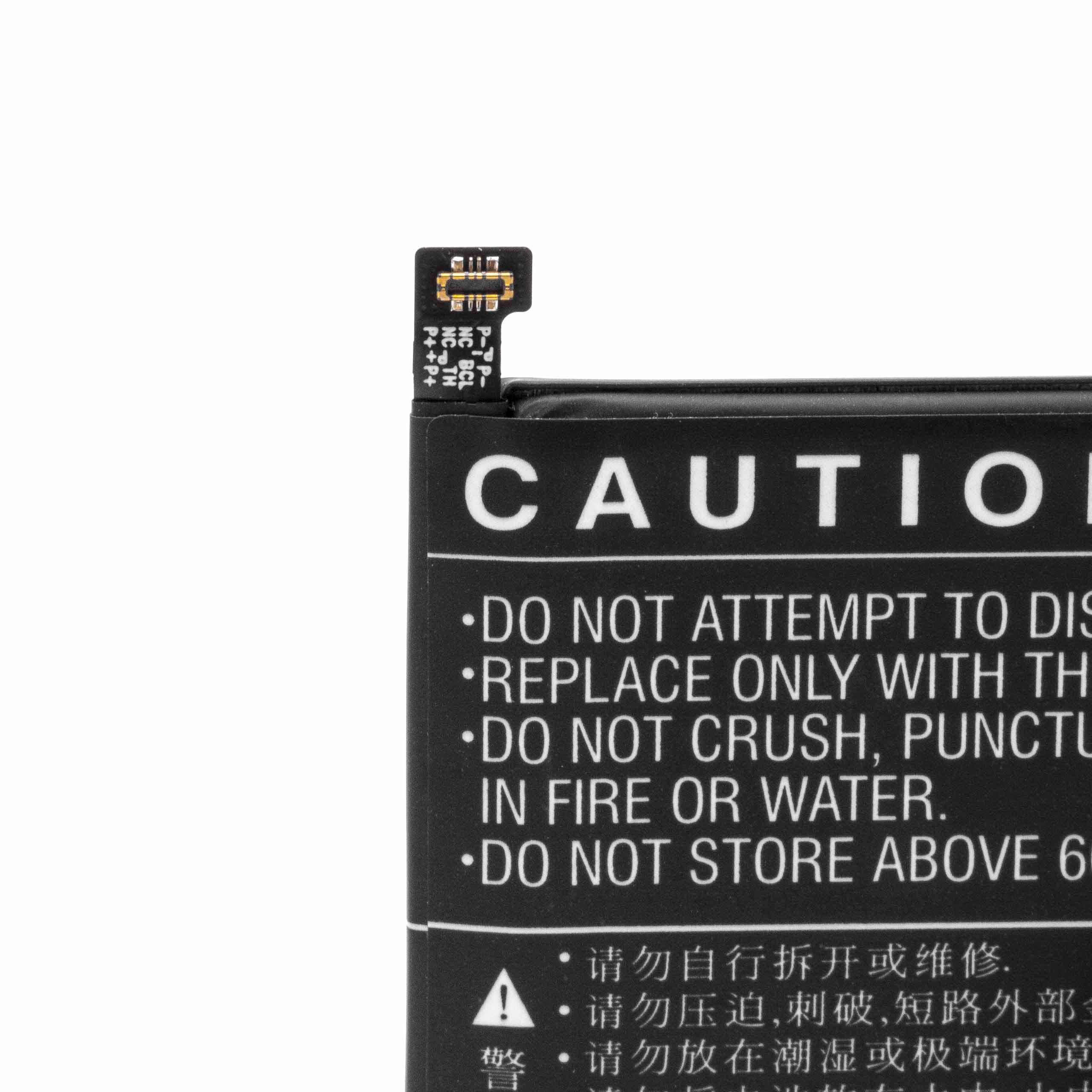 Nahaufnahme zeigt eine Batterie mit Warnhinweisen. Die Batterie ist schwarz mit weißer Schrift, oben befindet sich eine kleine Platine.