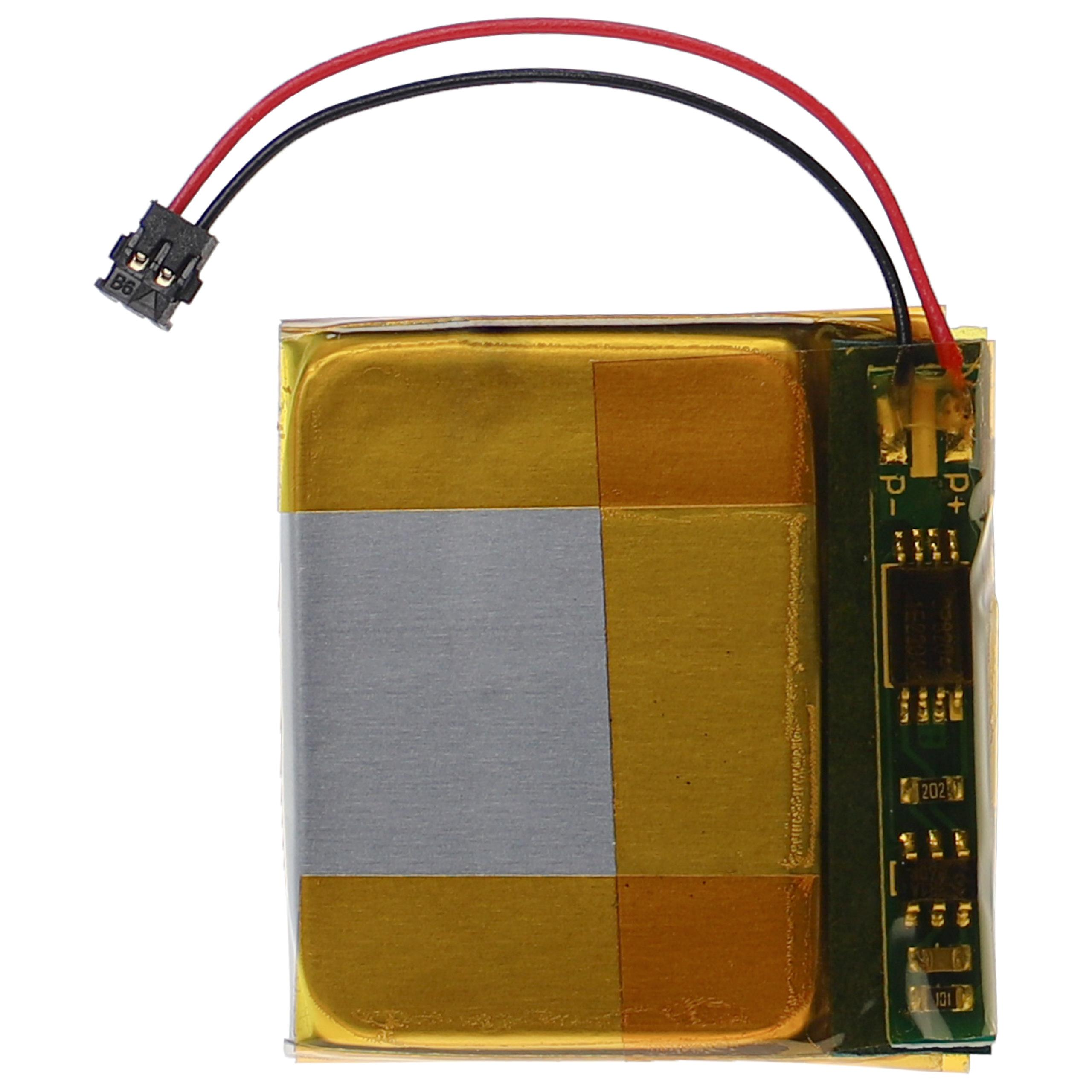 Eine Batterie mit goldener Umhüllung, einem silbernen Band, schwarzen und roten Drähten und einer grünen Platine mit Markierungen.