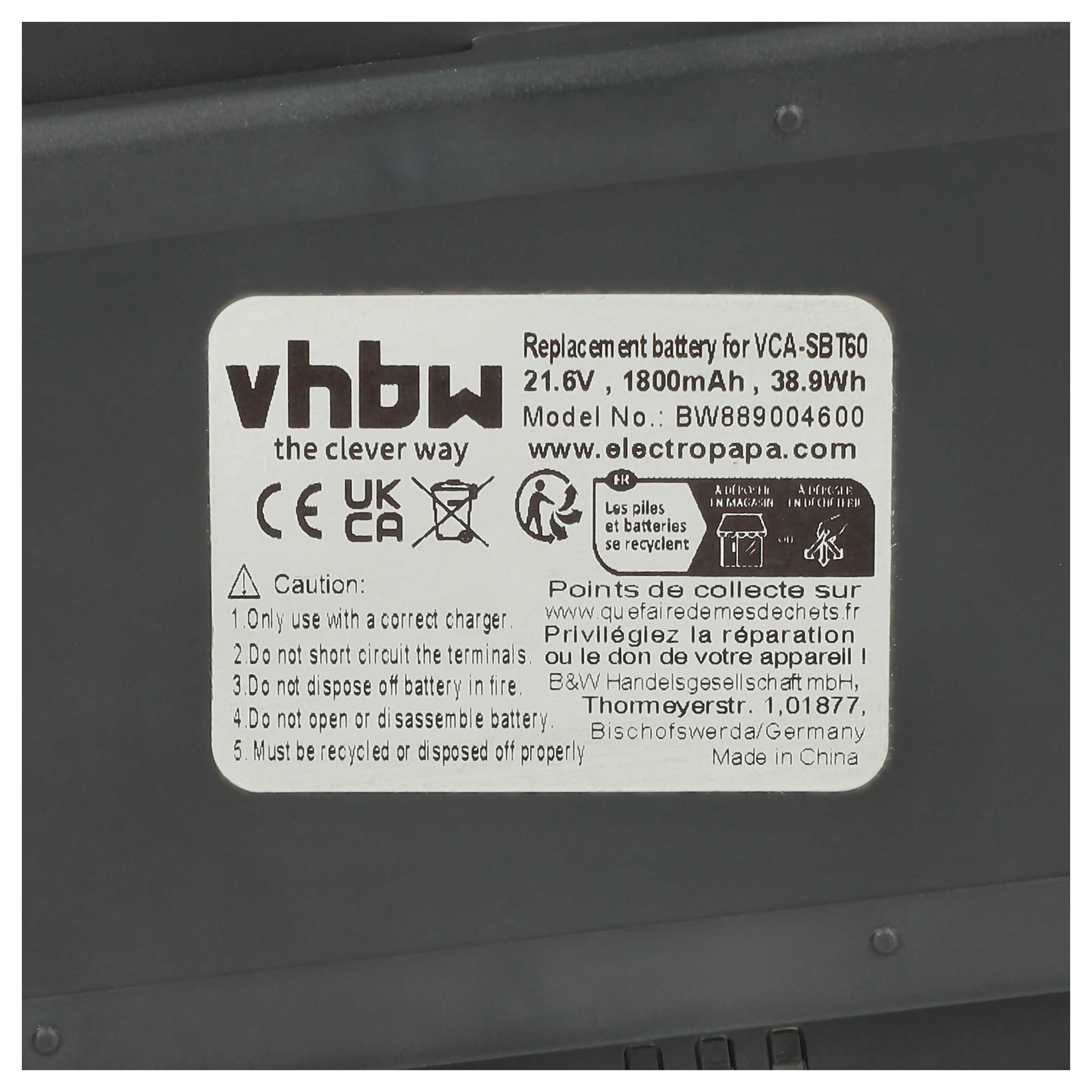 Ein schwarz-weißes Etikett mit Text und Symbolen befindet sich auf einer dunklen Oberfläche. Es ist ein Ersatzbatterieetikett.