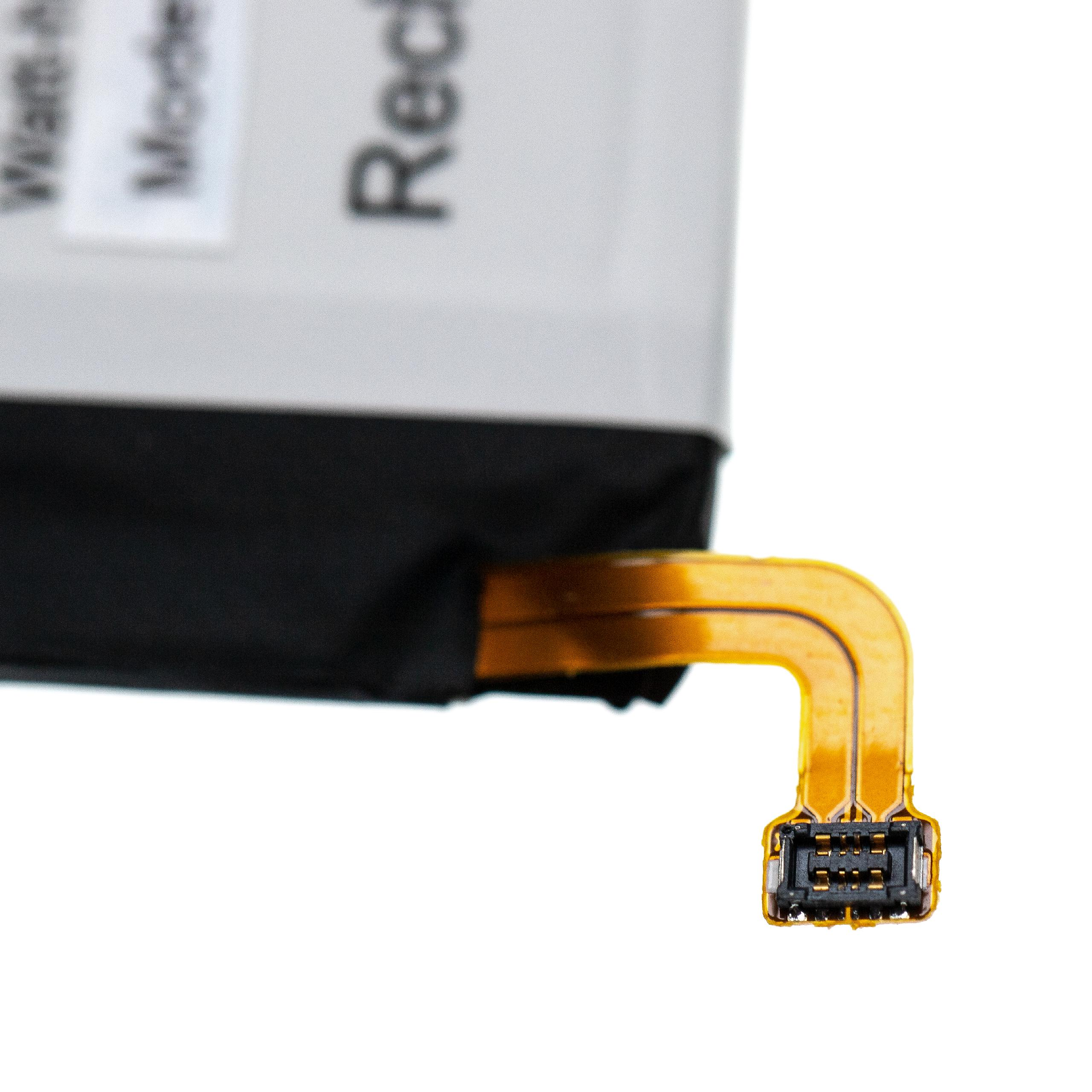 Nahaufnahme zeigt ein weißes Etikett mit Text. Eine flexible goldene Leiterplatte mit schwarzem Stecker ist ebenfalls sichtbar.