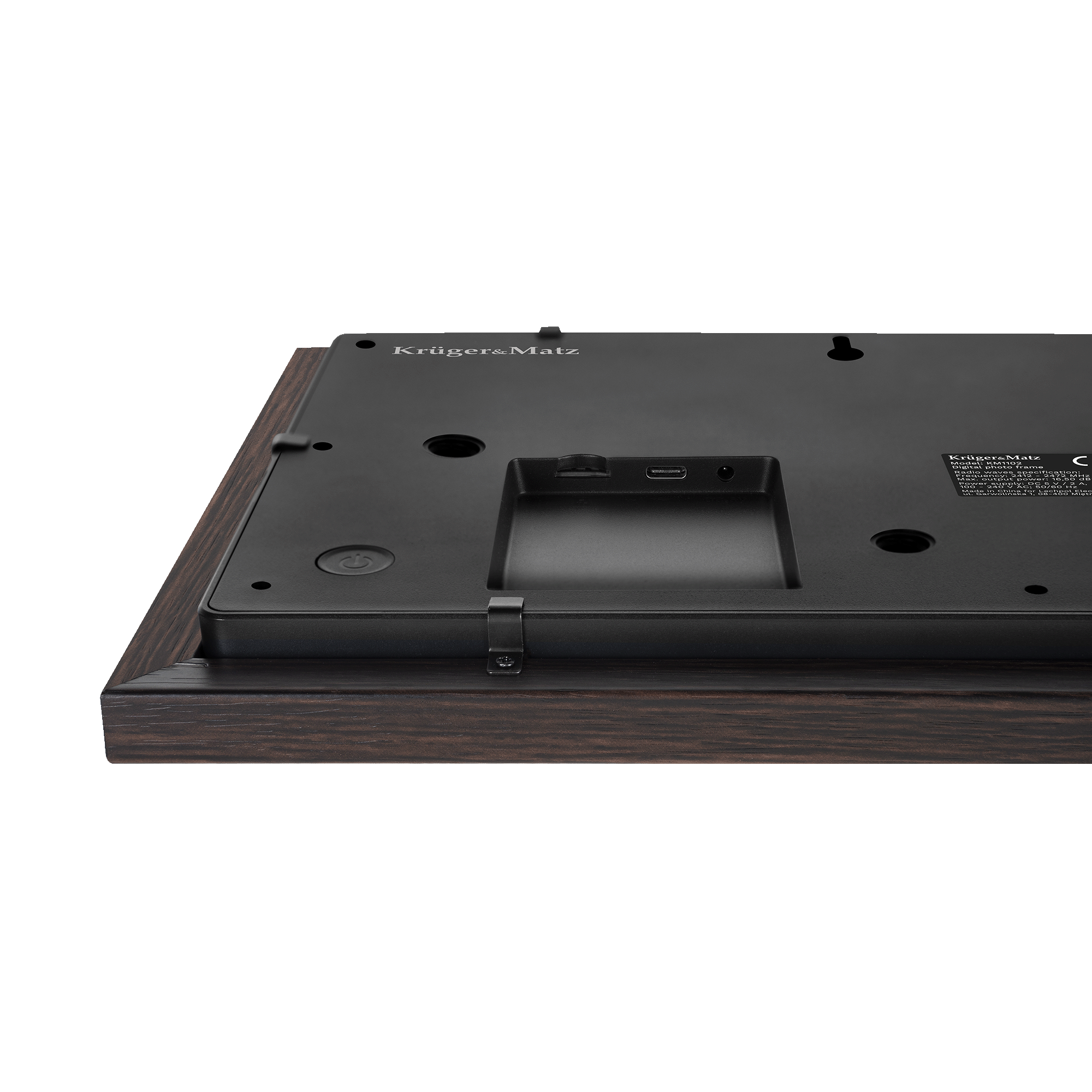 Tył czarnej cyfrowej ramki na zdjęcia. Jest osadzona w ciemnej drewnianej ramie i ma markę Krüger&Matz.