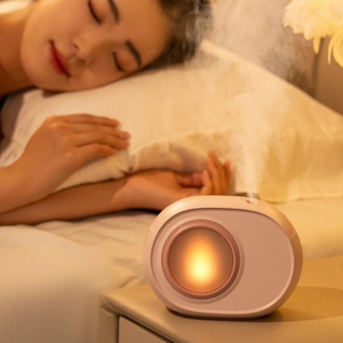 Eine schlafende Frau im Bett mit einem Luftbefeuchter daneben. Der Luftbefeuchter ist rosa und hat ein leuchtendes Licht.