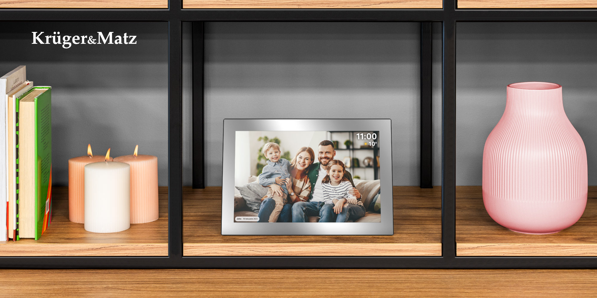 Na półce świece, cyfrowa ramka ze zdjęciem rodzinnym i różowy wazon. Ramka pokazuje rodzinę czteroosobową.
