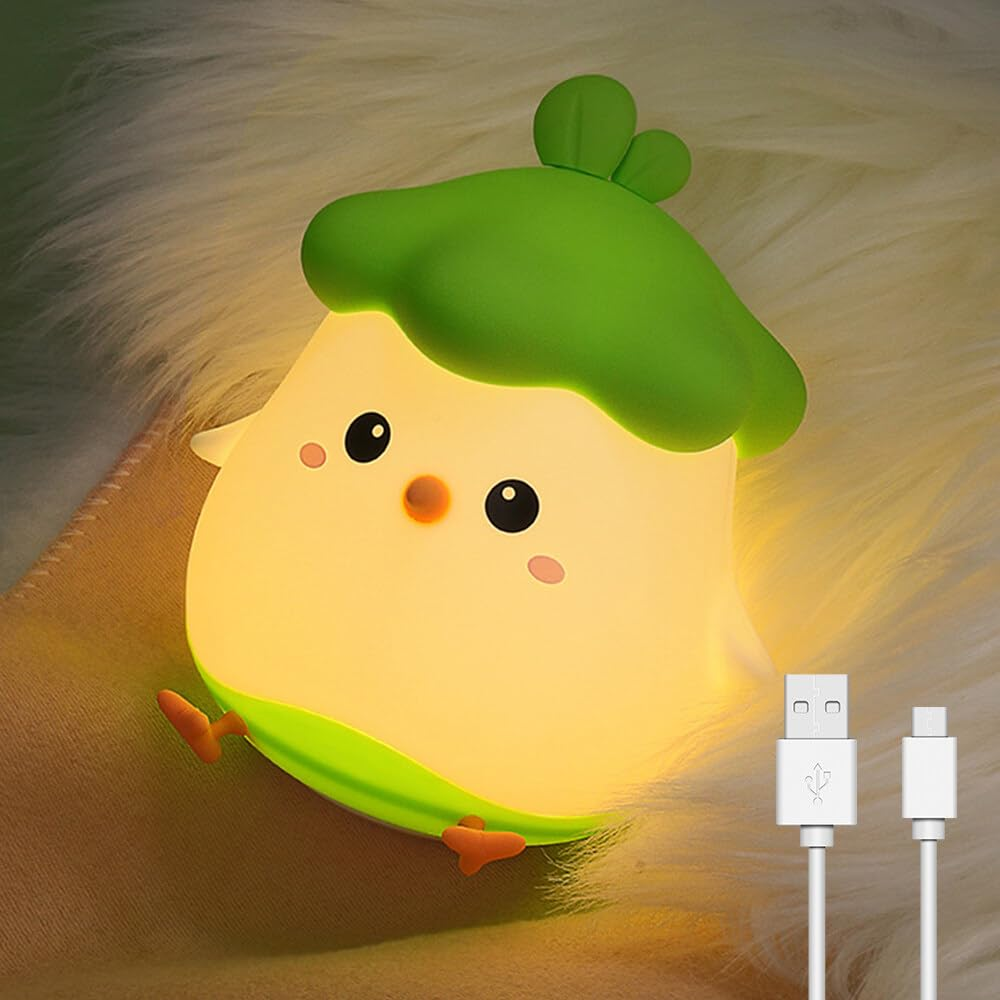 Ein niedliches, gelbes Küken-Nachtlicht mit grünem Hut auf einer flauschigen weißen Oberfläche. Weiße USB-Kabel rechts.