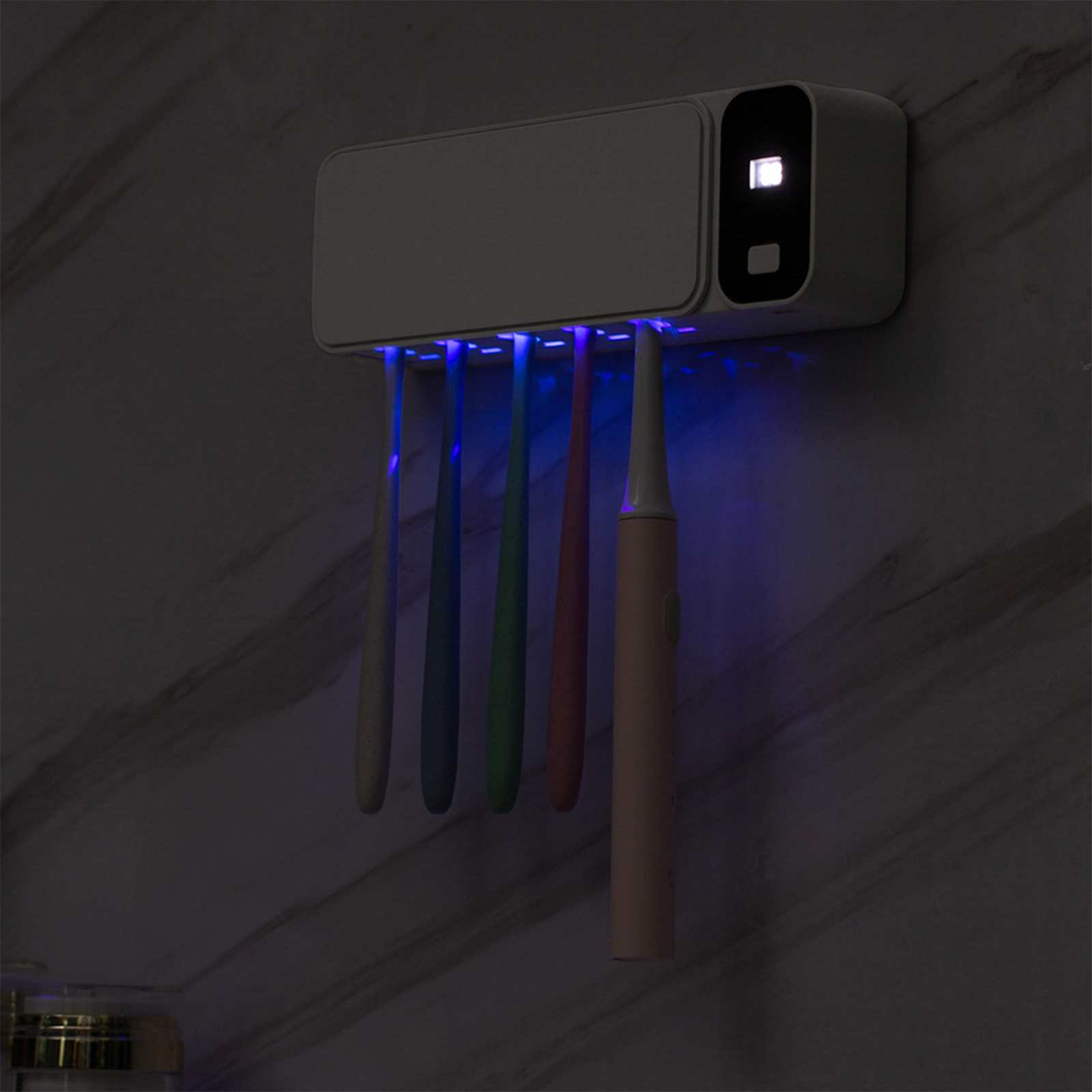 Ein weißer Zahnbürstensterilisator mit fünf unterschiedlich farbigen Zahnbürsten darunter, mit blauem Licht.