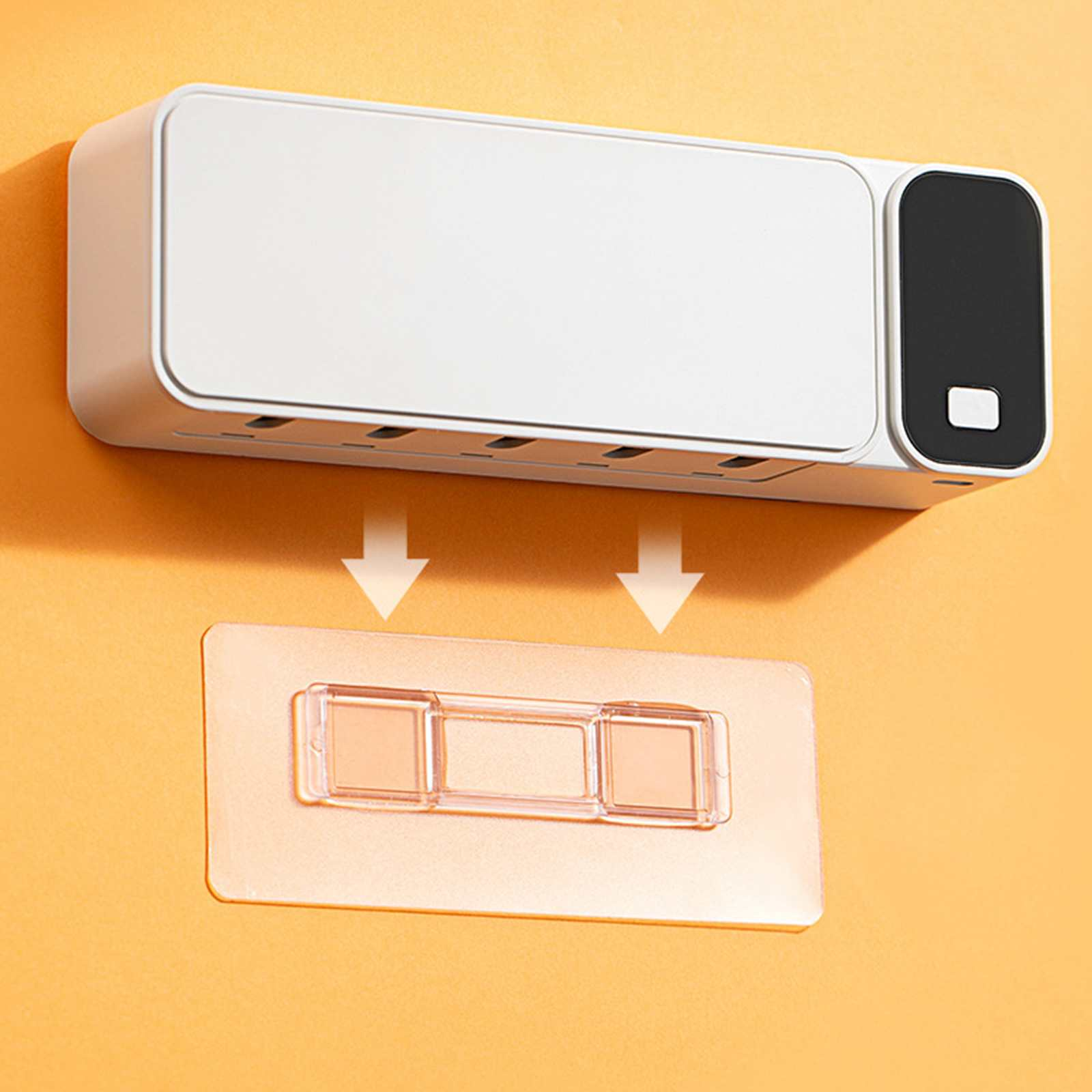 Ein weißes Verlängerungskabel mit schwarzem Ende befindet sich über einem transparenten Klebepad mit drei quadratischen Haltern an einer orangefarbenen Wand.