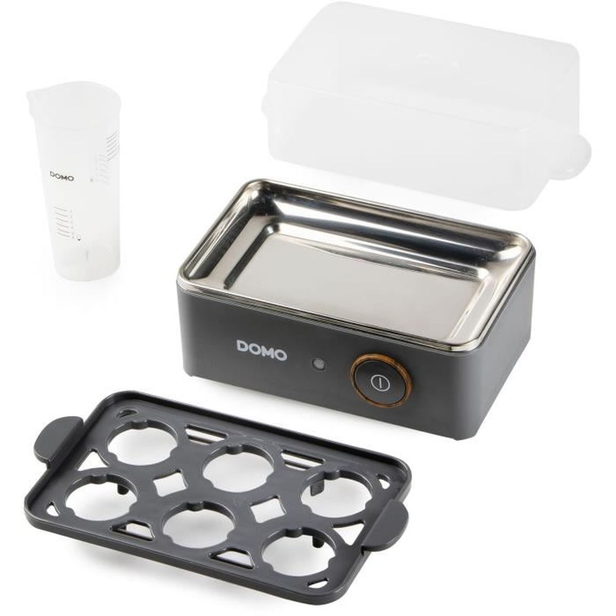 Gotowacz do jajek z akcesoriami: miarka, pokrywka, taca i sam gotowacz. Wszystko na białej powierzchni.