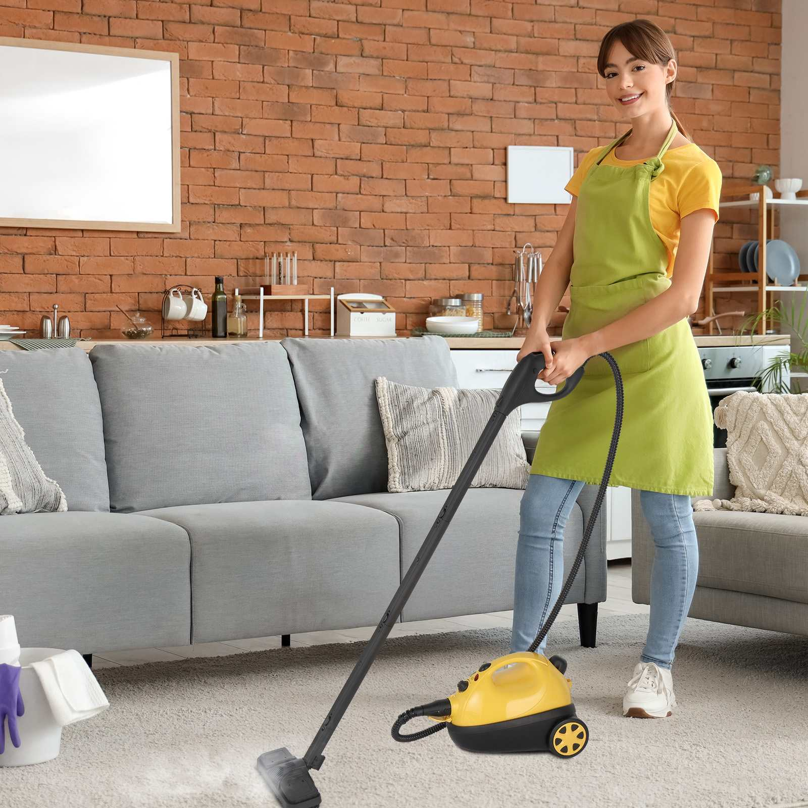 Eine Frau mit Schürze dampft einen Teppich. Der Raum hat ein graues Sofa, eine Ziegelmauer und einen gelb-schwarzen Dampfreiniger.