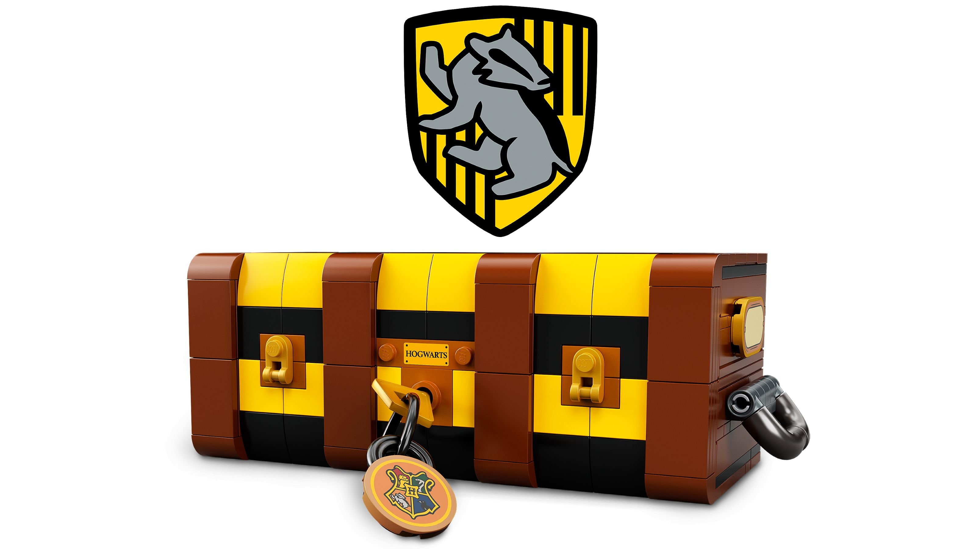 Eine Lego-Truhe mit dem Hufflepuff-Wappen darüber. Die Truhe ist braun und gelb mit Schloss und Schlüssel. Der Hintergrund ist weiß.