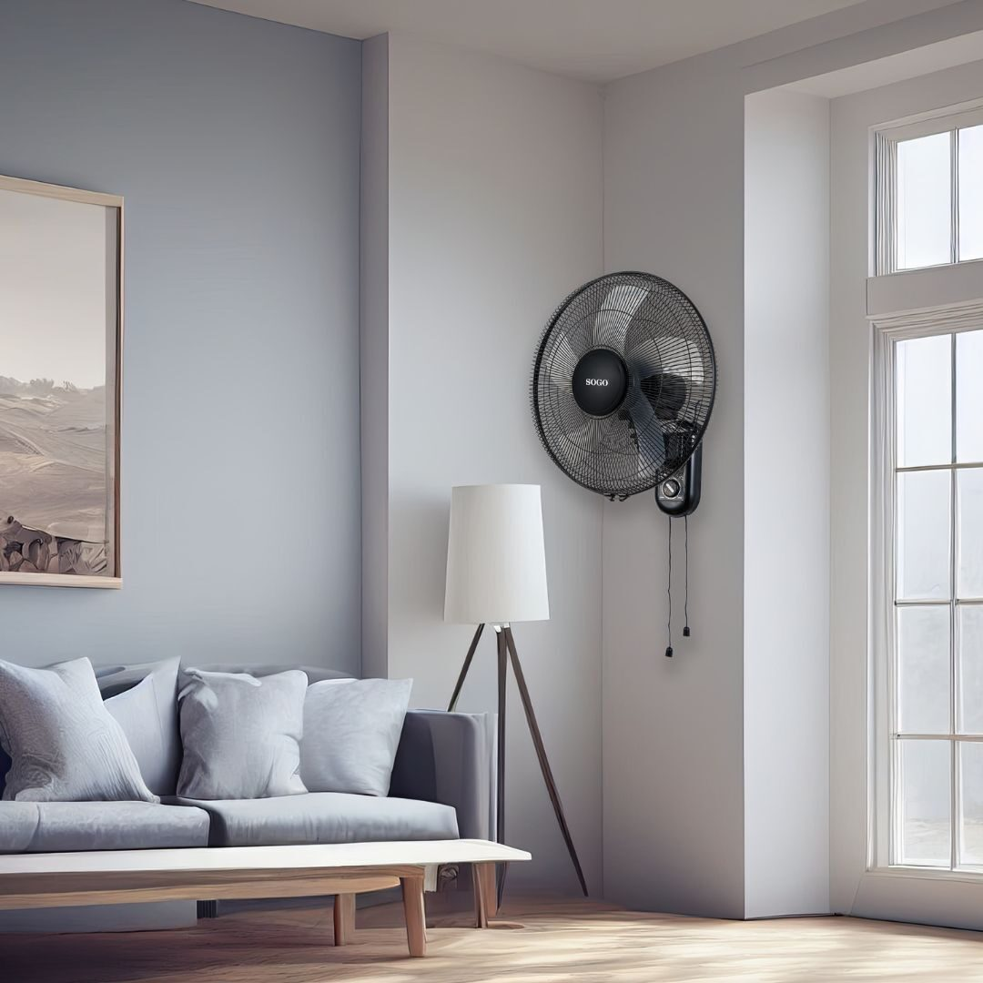 Un salón moderno con ventilador de pared, sofá con almohadas, lámpara de pie, mesa y ventana. Las paredes son grises claras.