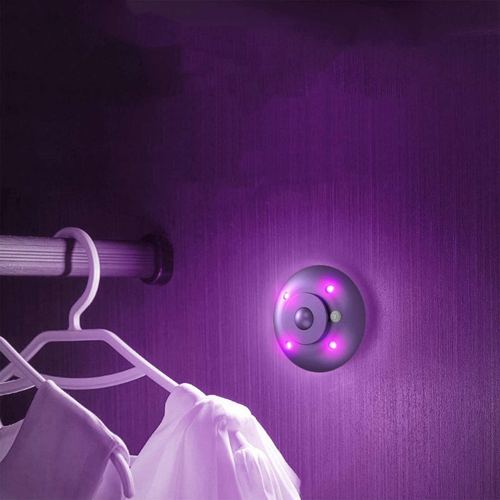 Innenraum eines lila beleuchteten Schranks mit Sensorlicht. Kleiderbügel halten Kleidung. Das Sensorlicht ist kreisförmig und hat leuchtende LEDs.