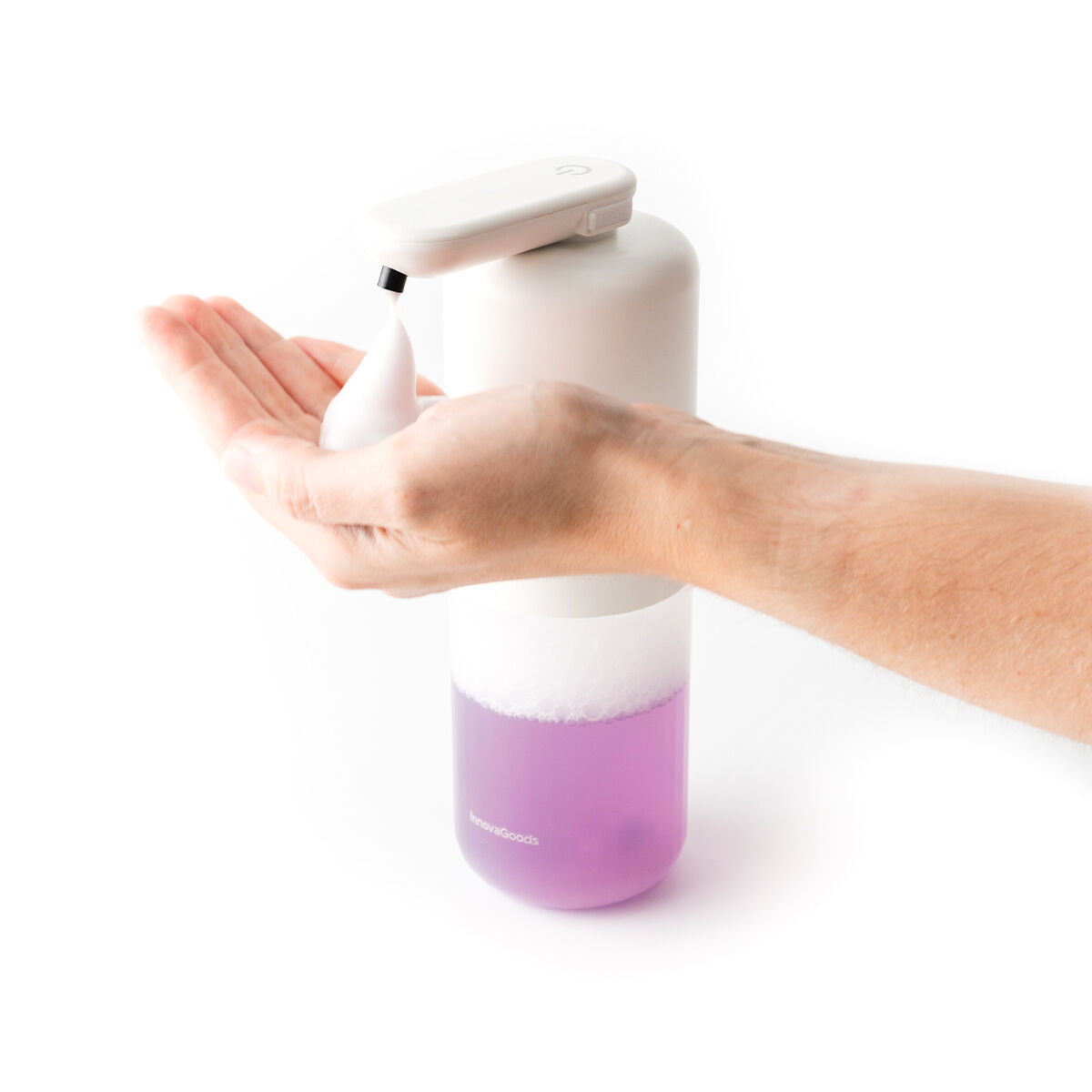 Eine Hand empfängt weißen Schaum aus einem weißen und lila automatischen Seifenspender. Der Spender befindet sich auf weißem Hintergrund.
