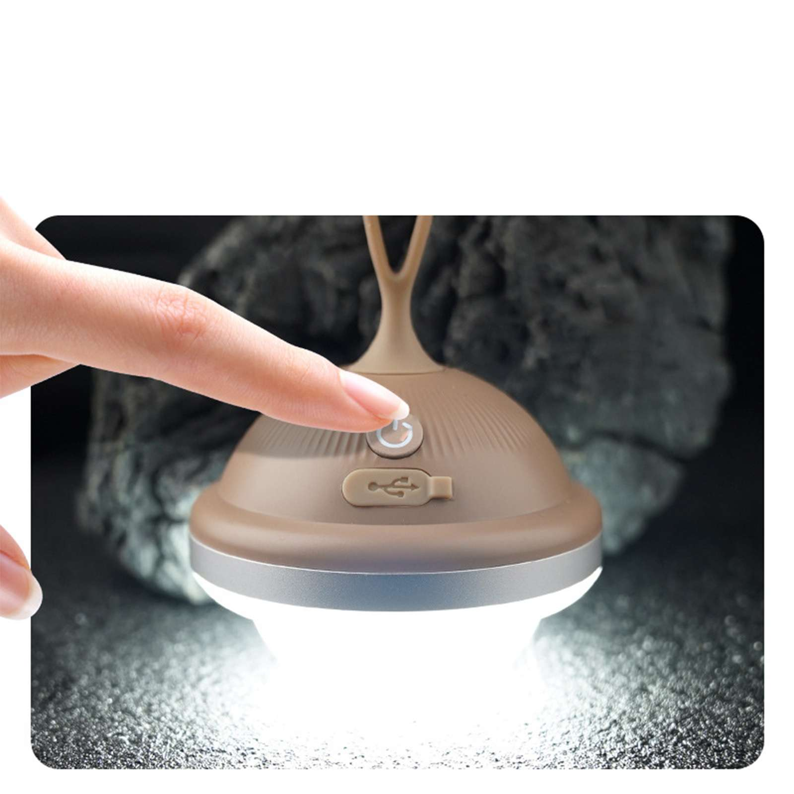 Eine Hand drückt den Ein- und Ausschalter einer braunen Lampe. Die Lampe leuchtet, im Hintergrund ein Felsen.