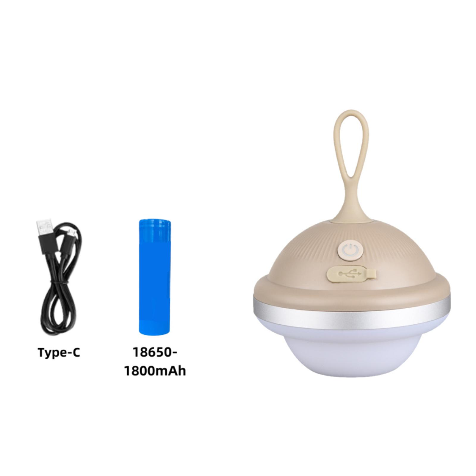 Eine beige Lampe mit Griff, eine blaue Batterie und ein USB-Kabel auf weißem Untergrund.