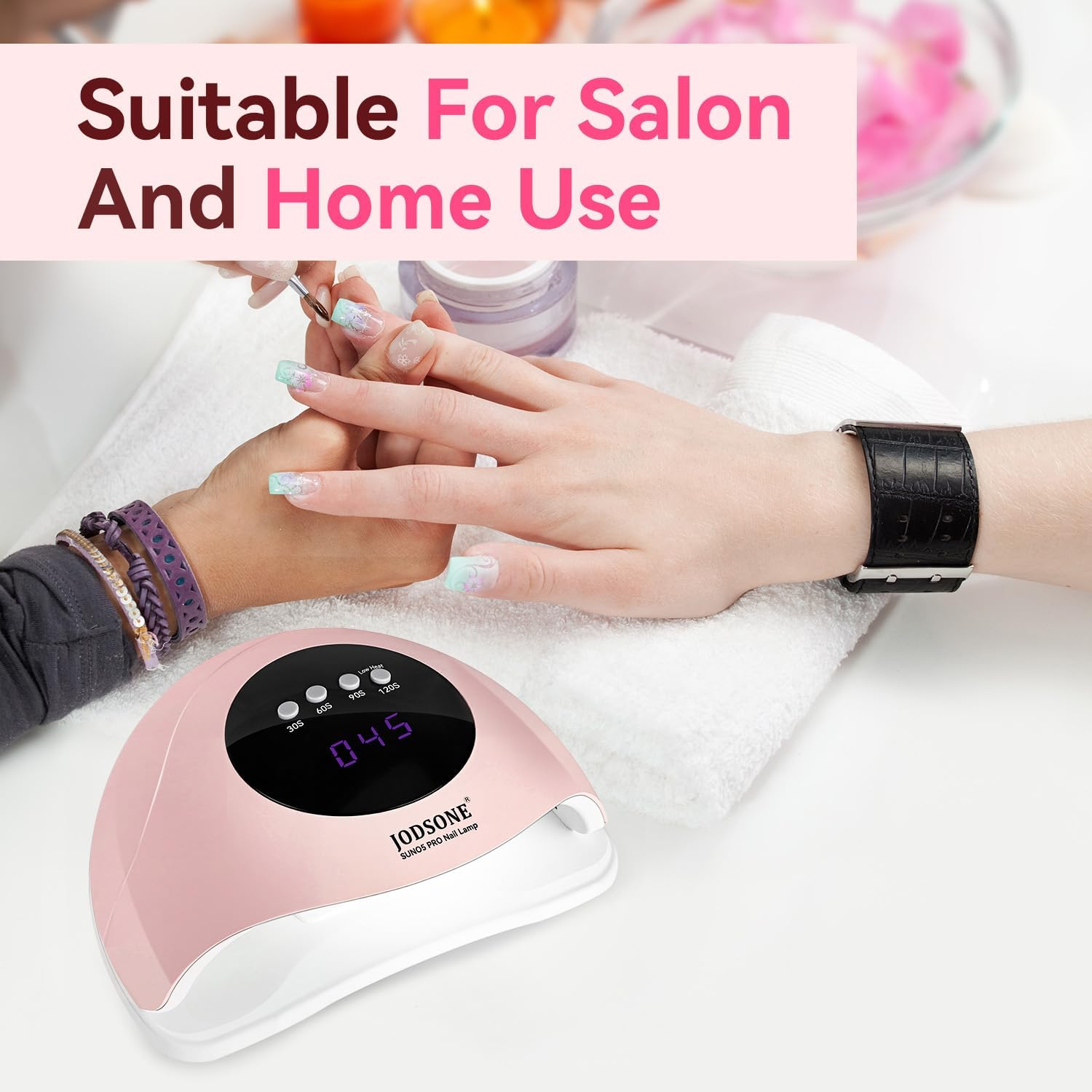 Hände mit Nagellack, eine rosa Nagellampe und eine schwarze Uhr auf weißem Untergrund. Der Text lautet 'Geeignet für Salon und Heimgebrauch'.