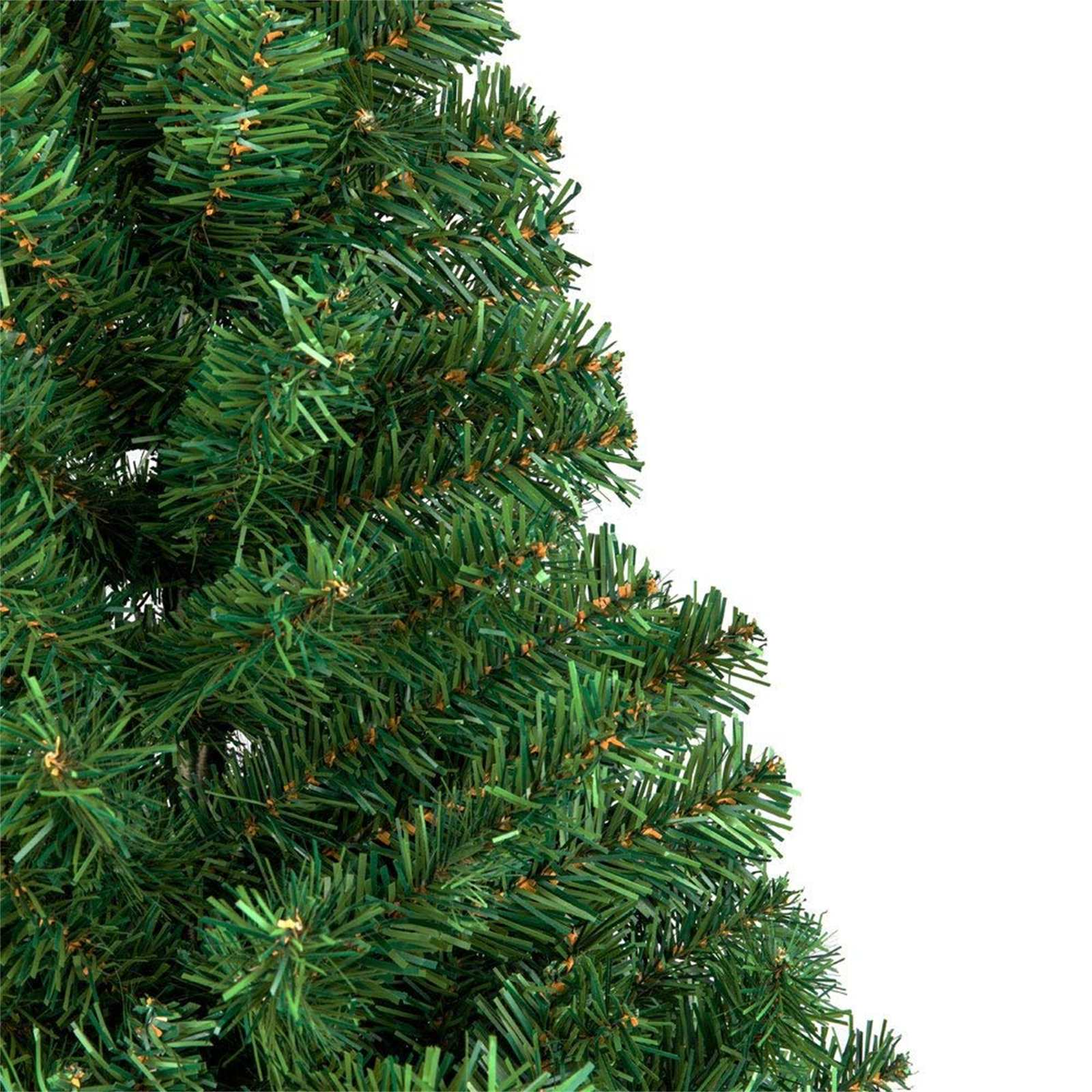 Nahaufnahme eines grünen künstlichen Weihnachtsbaumzweigs. Die Nadeln sind tiefgrün, mit kleinen braunen Spitzen, vor weißem Hintergrund.
