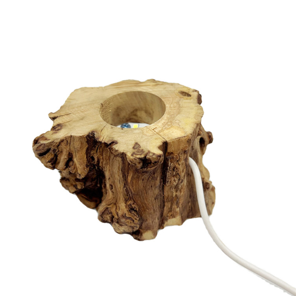 Ein Holzstumpf mit einem Loch in der Mitte. Ein weißes Kabel tritt aus der Seite aus. Der Hintergrund ist weiß.