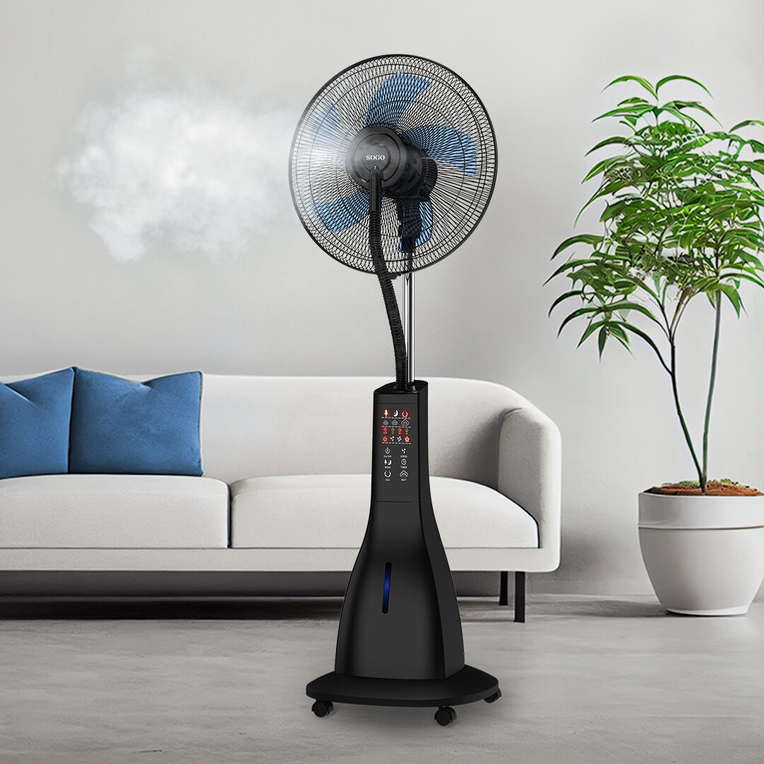 Czarny wentylator mgiełkowy z niebieskimi łopatkami stoi w pokoju. Widoczna jest również biała sofa z niebieskimi poduszkami i roślina doniczkowa.