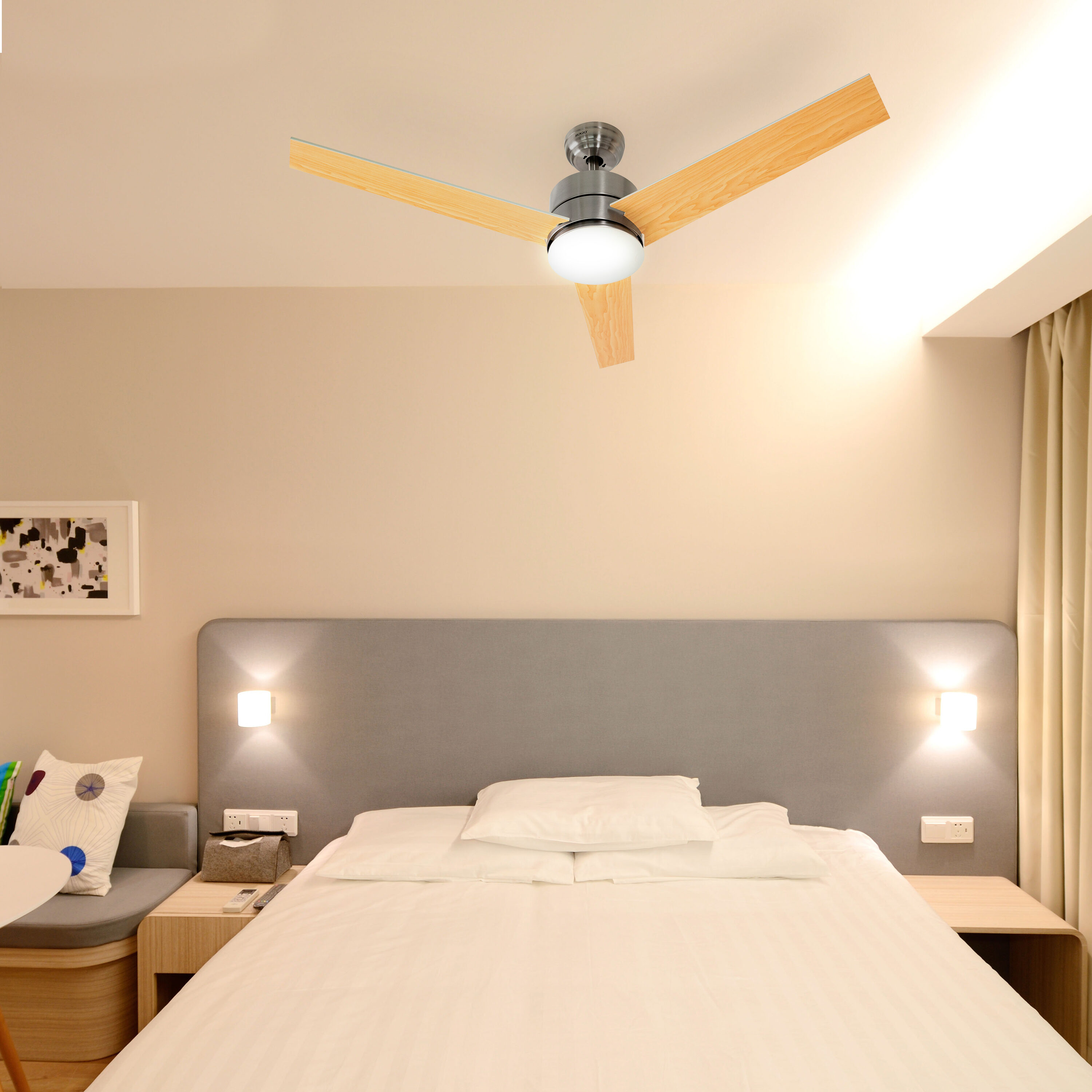Una camera da letto con letto, lampade e ventilatore a soffitto. Il letto ha lenzuola bianche. Il ventilatore ha pale in legno.