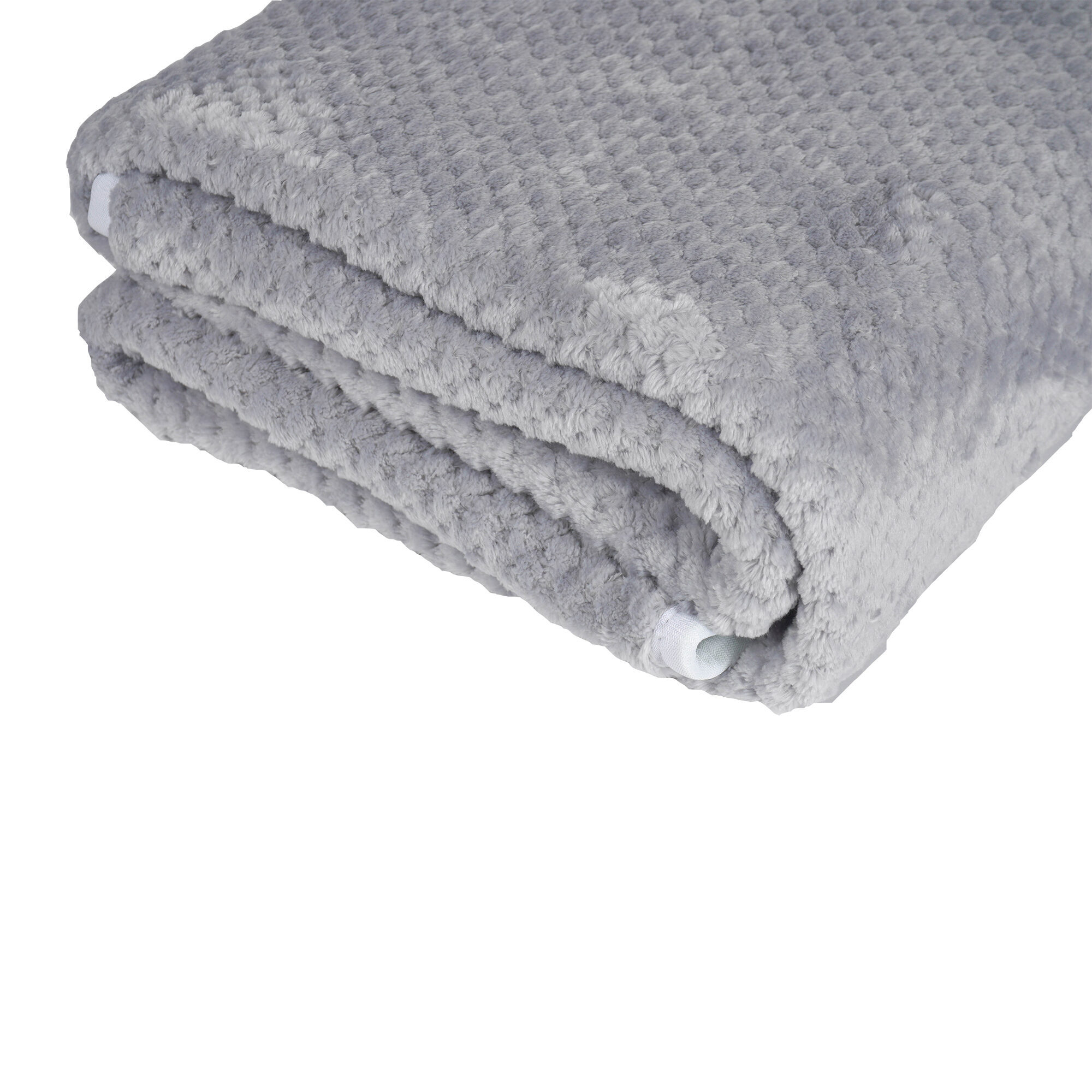 Una manta de felpa gris doblada con superficie texturizada. Se ve tela blanca en los bordes. El fondo es blanco.