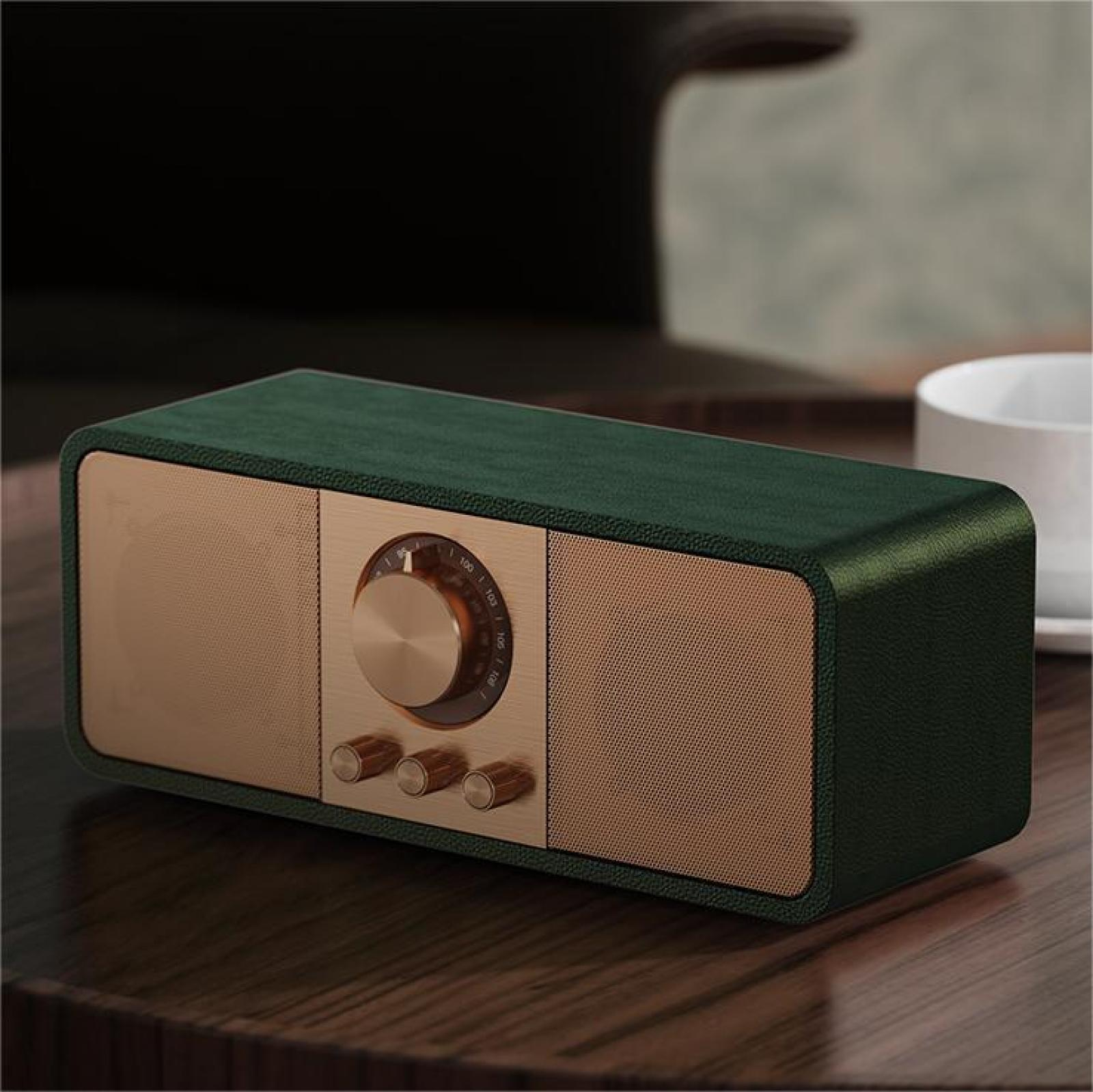 Ein Retro-Radio in Grün und Gold steht auf einem Holztisch. Im Hintergrund befindet sich eine weiße Tasse.