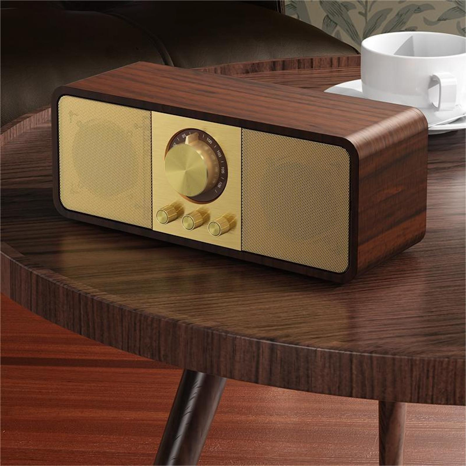 Ein Holzradio mit goldenen Lautsprecherabdeckungen und Knöpfen steht auf einem Holztisch. Daneben steht eine weiße Tasse.