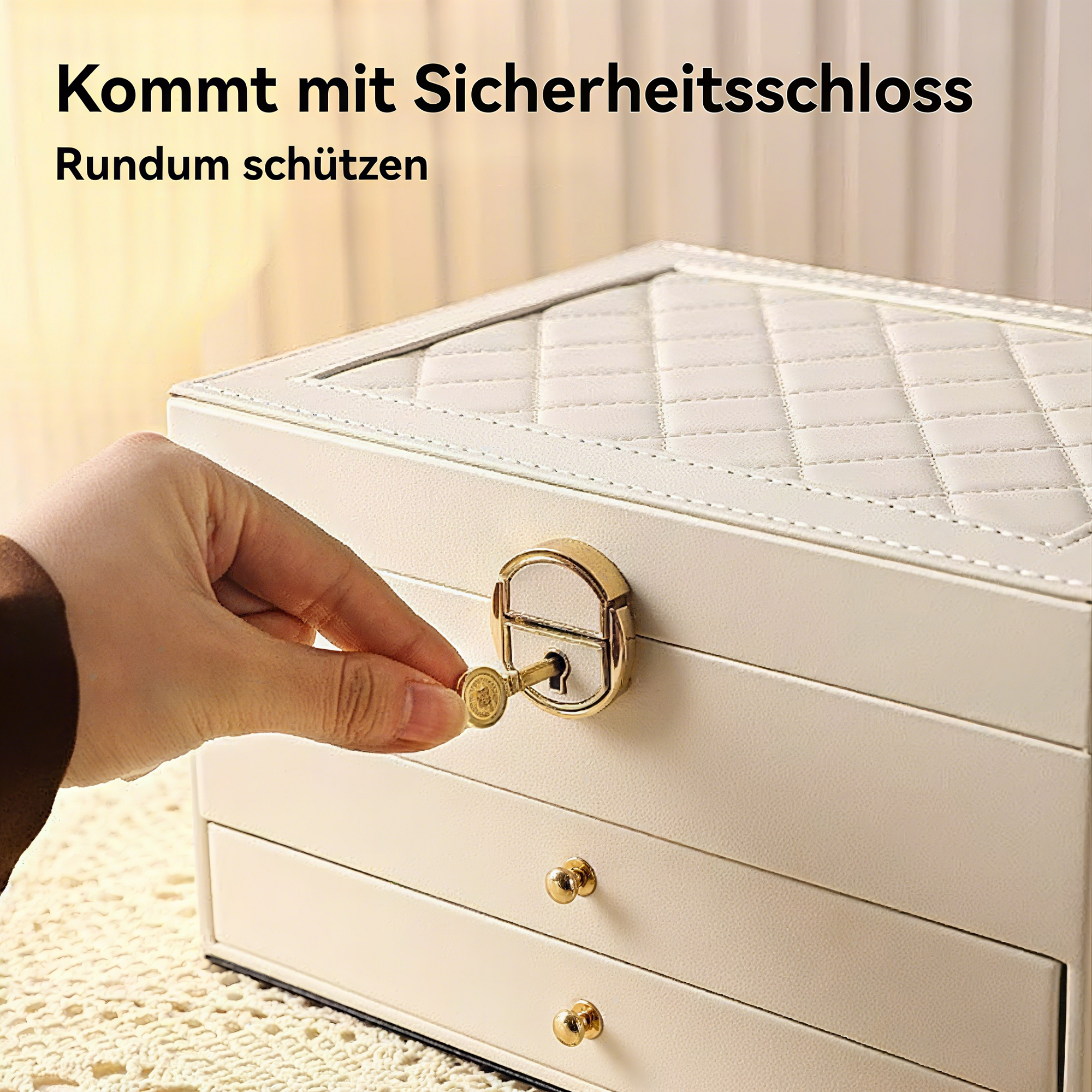 Eine Hand steckt einen Schlüssel in ein goldenes Schloss einer weißen Schmuckschatulle. Die Box hat Schubladen und eine gesteppte Oberseite.