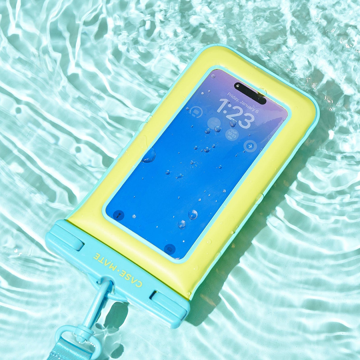 Un telefono in una custodia impermeabile galleggia nell'acqua. La custodia è gialla e blu, lo schermo mostra l'ora.