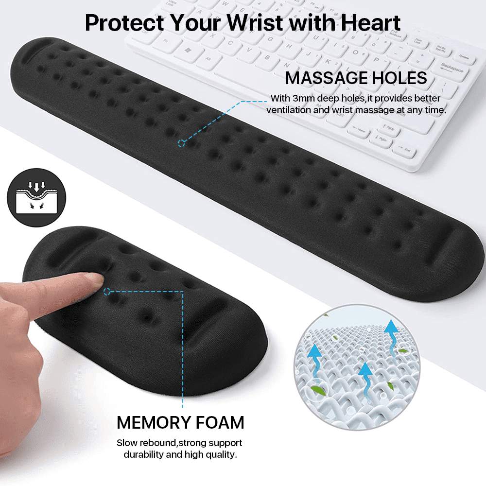 Eine schwarze Handgelenkstütze mit Massageöffnungen liegt auf einer weißen Tastatur. Sie besteht aus Memory-Schaum. Ein Finger zeigt auf die Löcher.