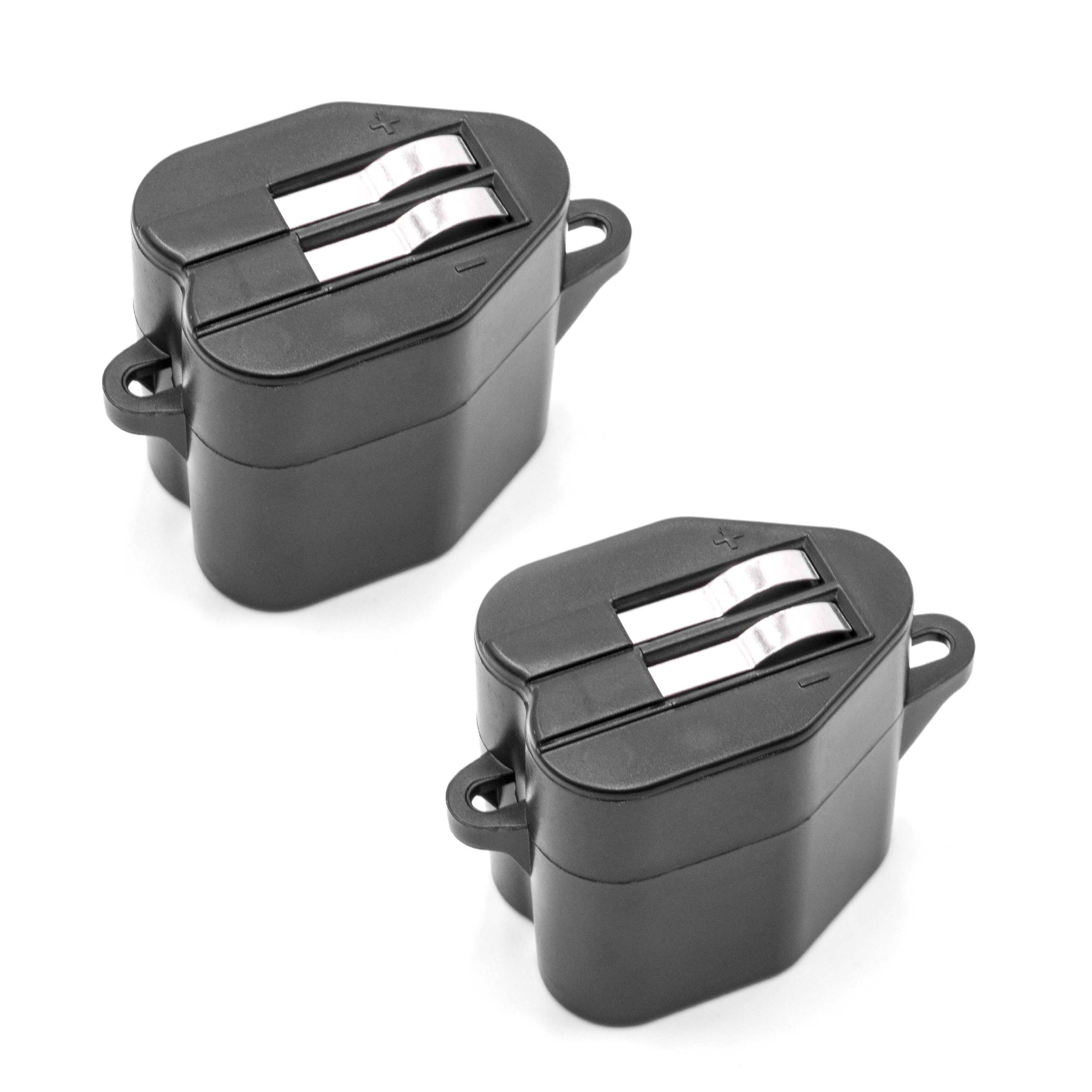 Zwei schwarze Batterieklemmen mit silbernen Kontakten. Der Hintergrund ist weiß.