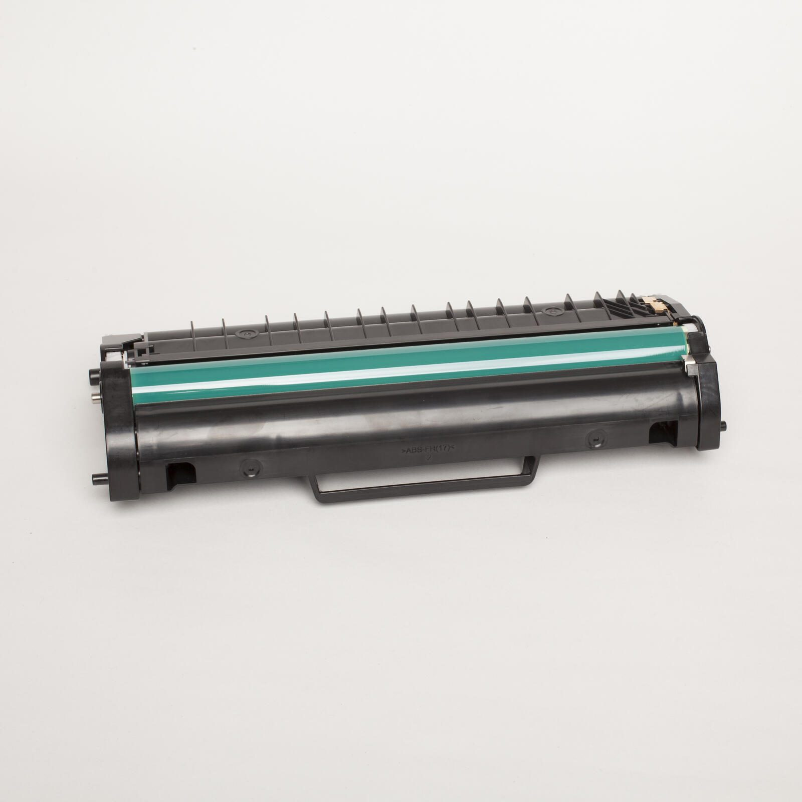 Cartuccia toner nera con una striscia verde, su una superficie bianca.