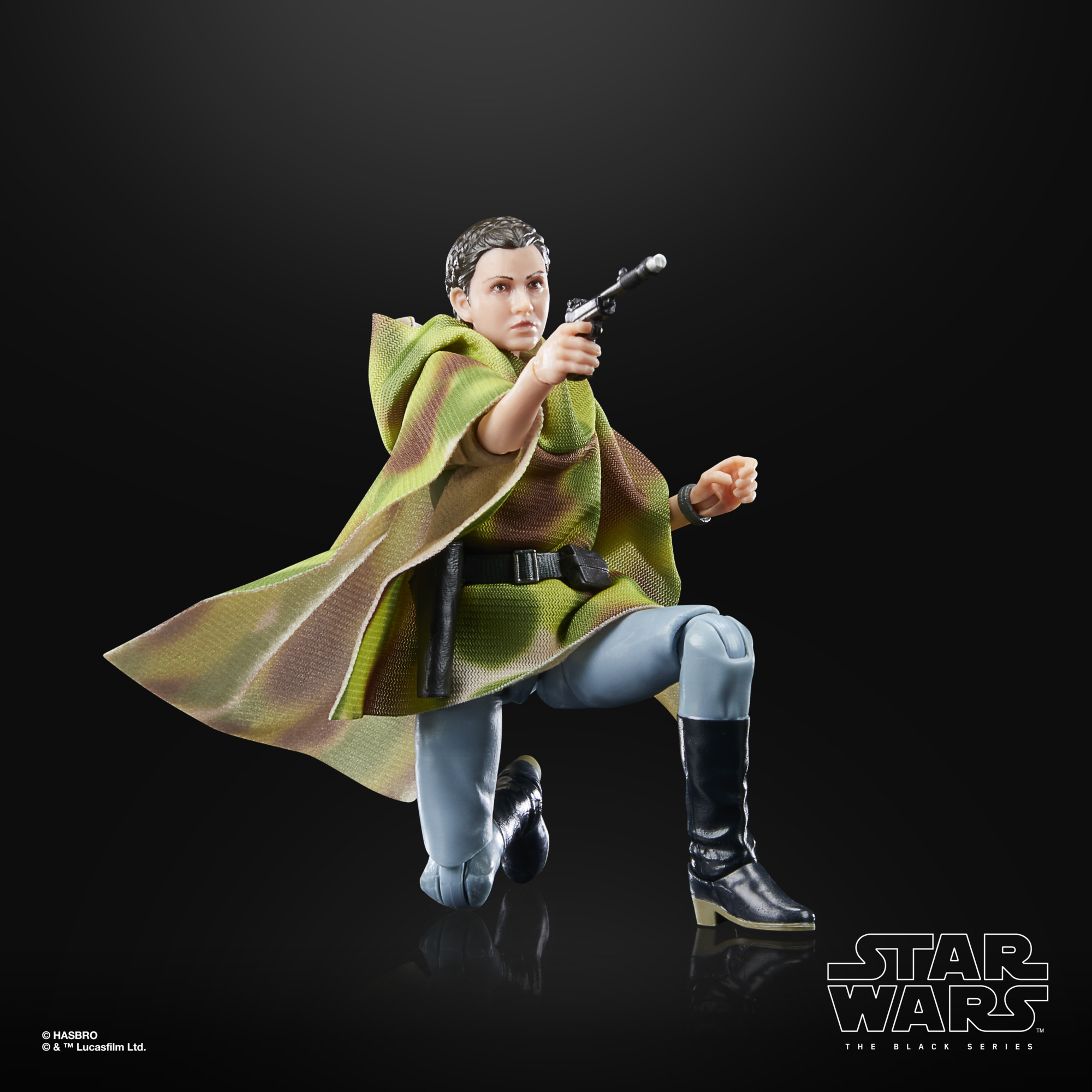 Una figura de acción de Star Wars se arrodilla, apuntando un bláster. La figura lleva una capa verde y marrón, pantalones azules claros y botas negras.