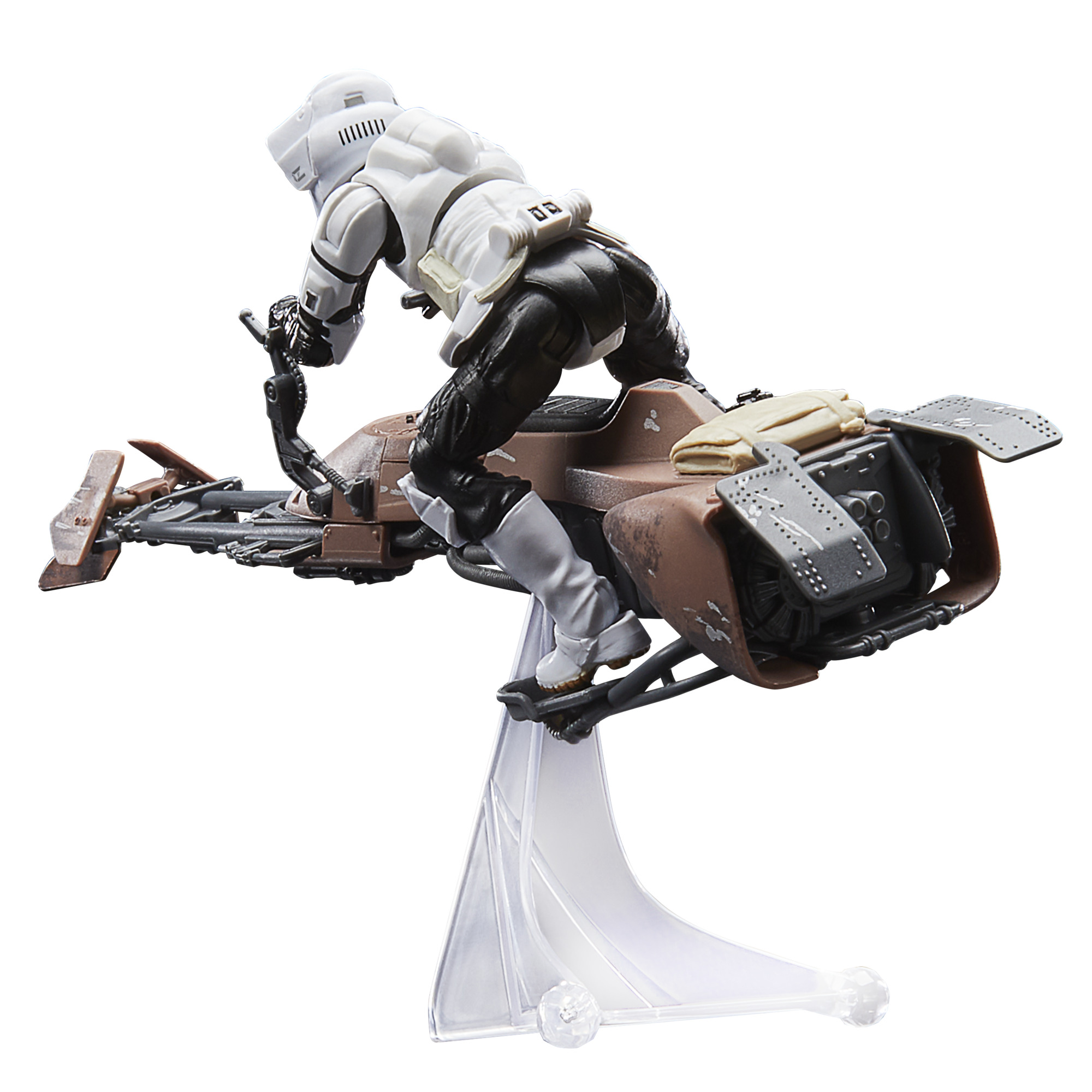 Bir Star Wars Scout Trooper figürü bir speeder bisikletine biniyor. Figür beyaz ve siyahtır. Bisiklet kahverengi ve gridir, bir stand üzerinde.