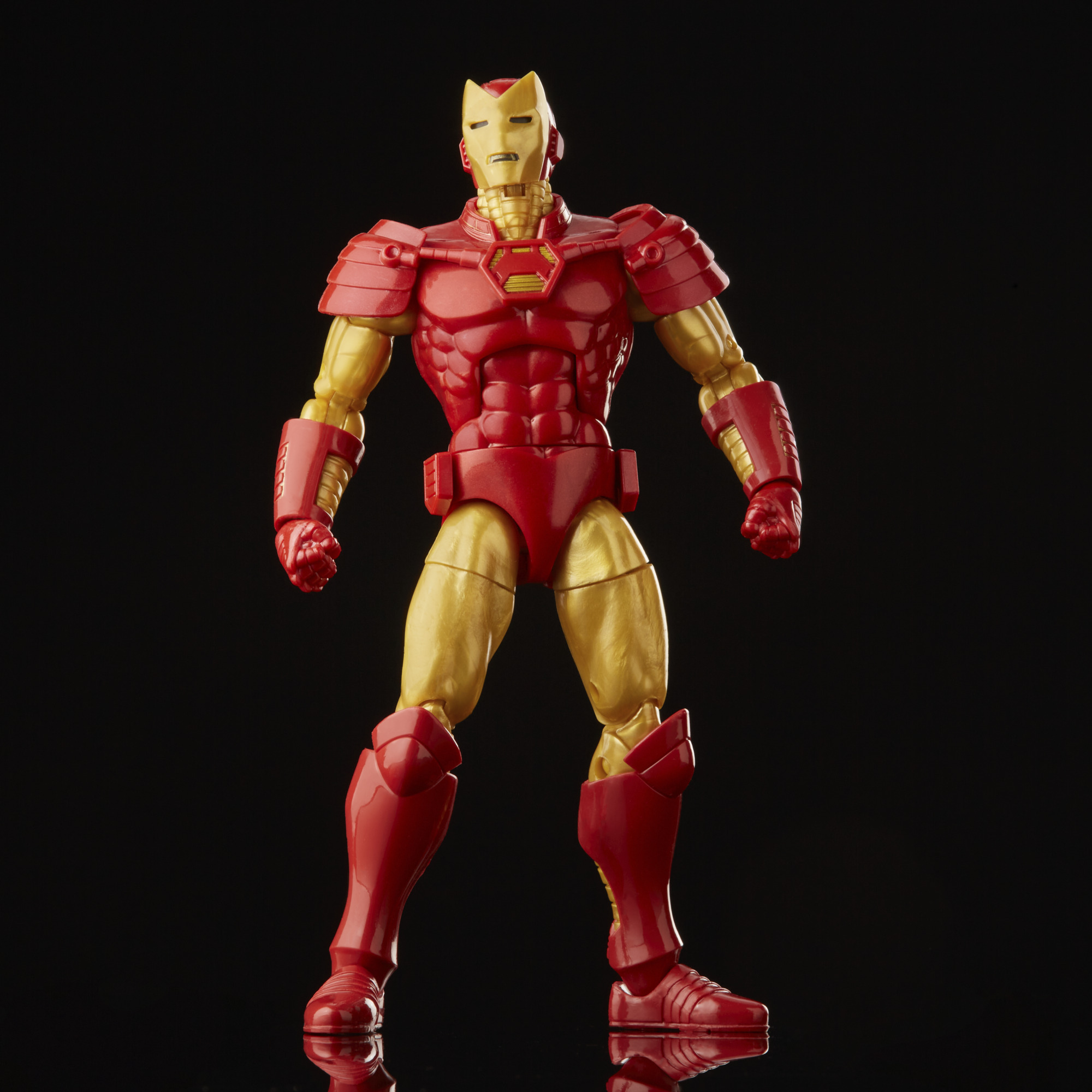 Action figure di Iron Man, armatura rossa e oro, in piedi su sfondo nero, con riflessi.