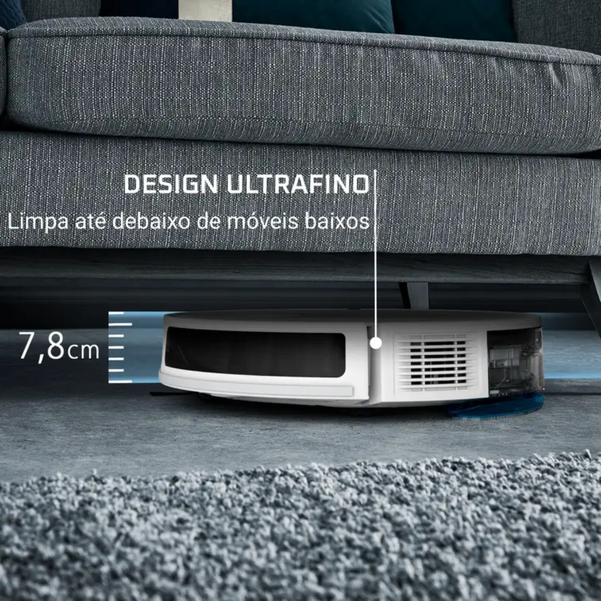 Biały odkurzacz robot sprząta pod szarą sofą. Tekst wskazuje, że jest ultracienki i sprząta pod niskimi meblami.