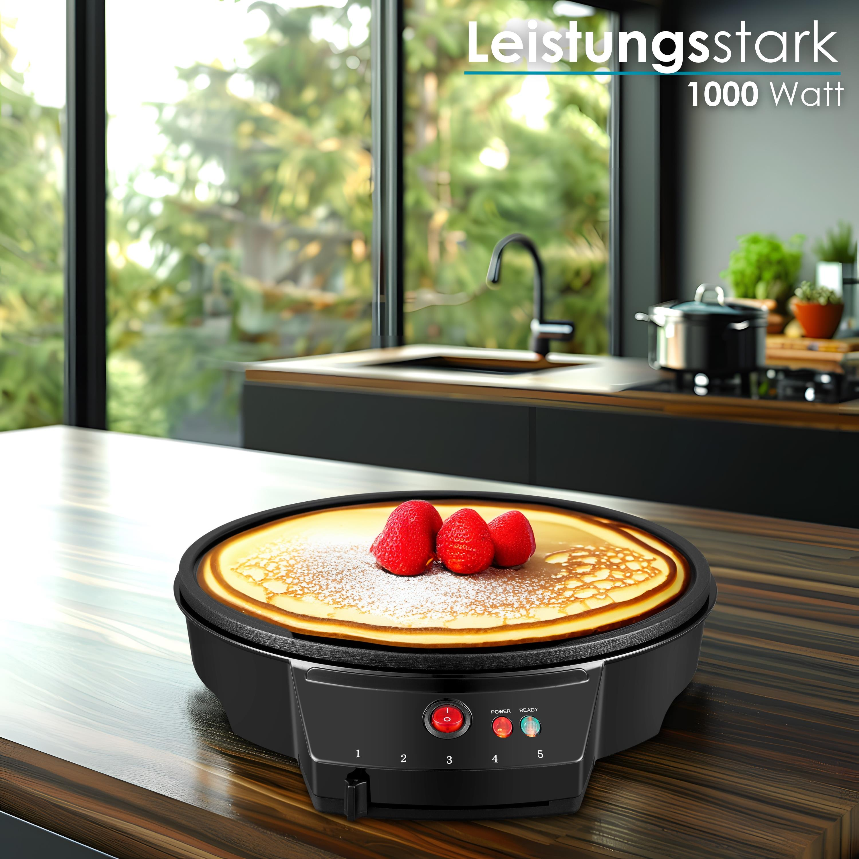 Ein Crêpes-Maker mit einem Pfannkuchen, der mit Erdbeeren belegt ist. Ein Küchenhintergrund ist sichtbar.