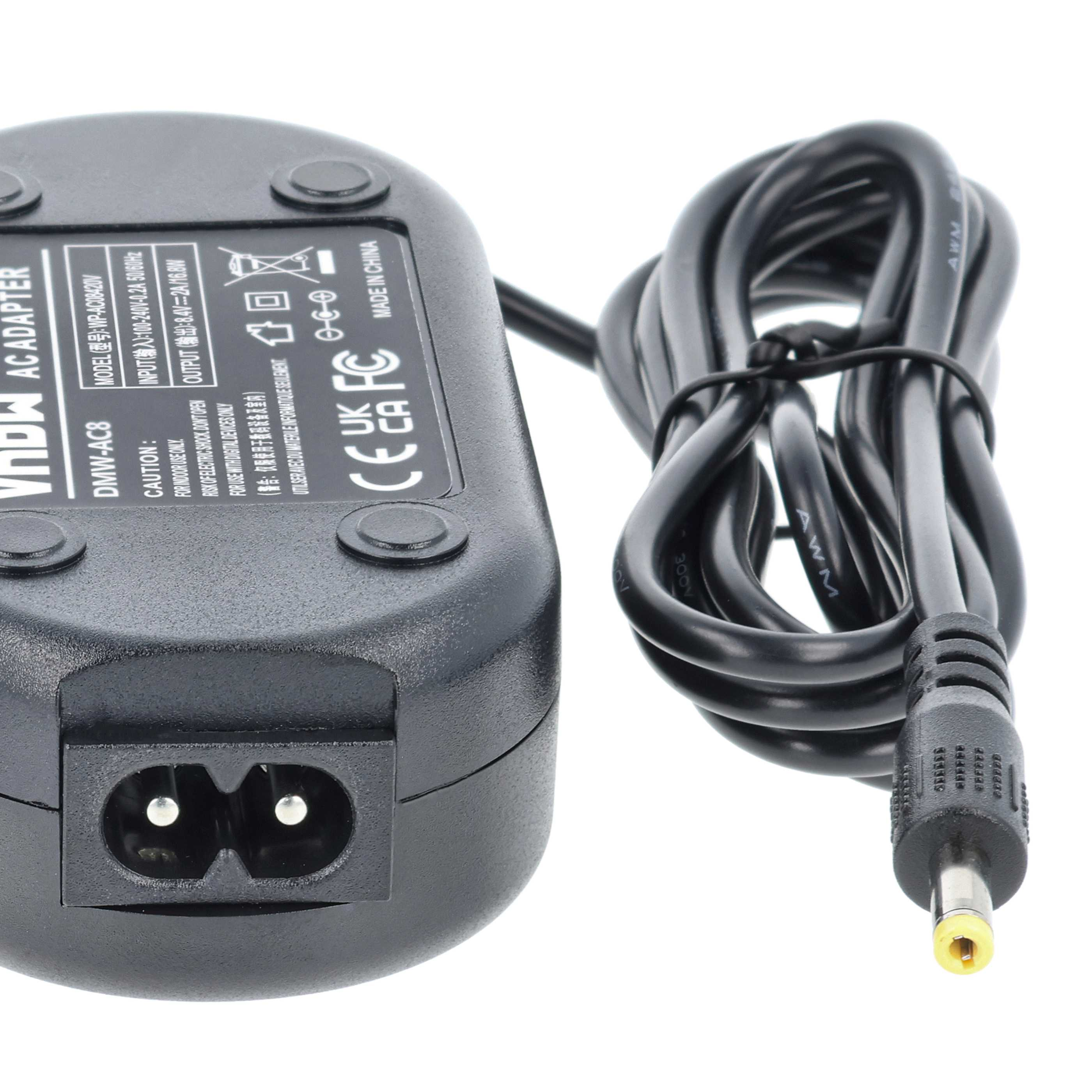 Ein schwarzes AC-Adapter mit einem schwarzen Kabel. Der Adapter hat einen Netzstecker und ist beschriftet. Weißer Hintergrund.