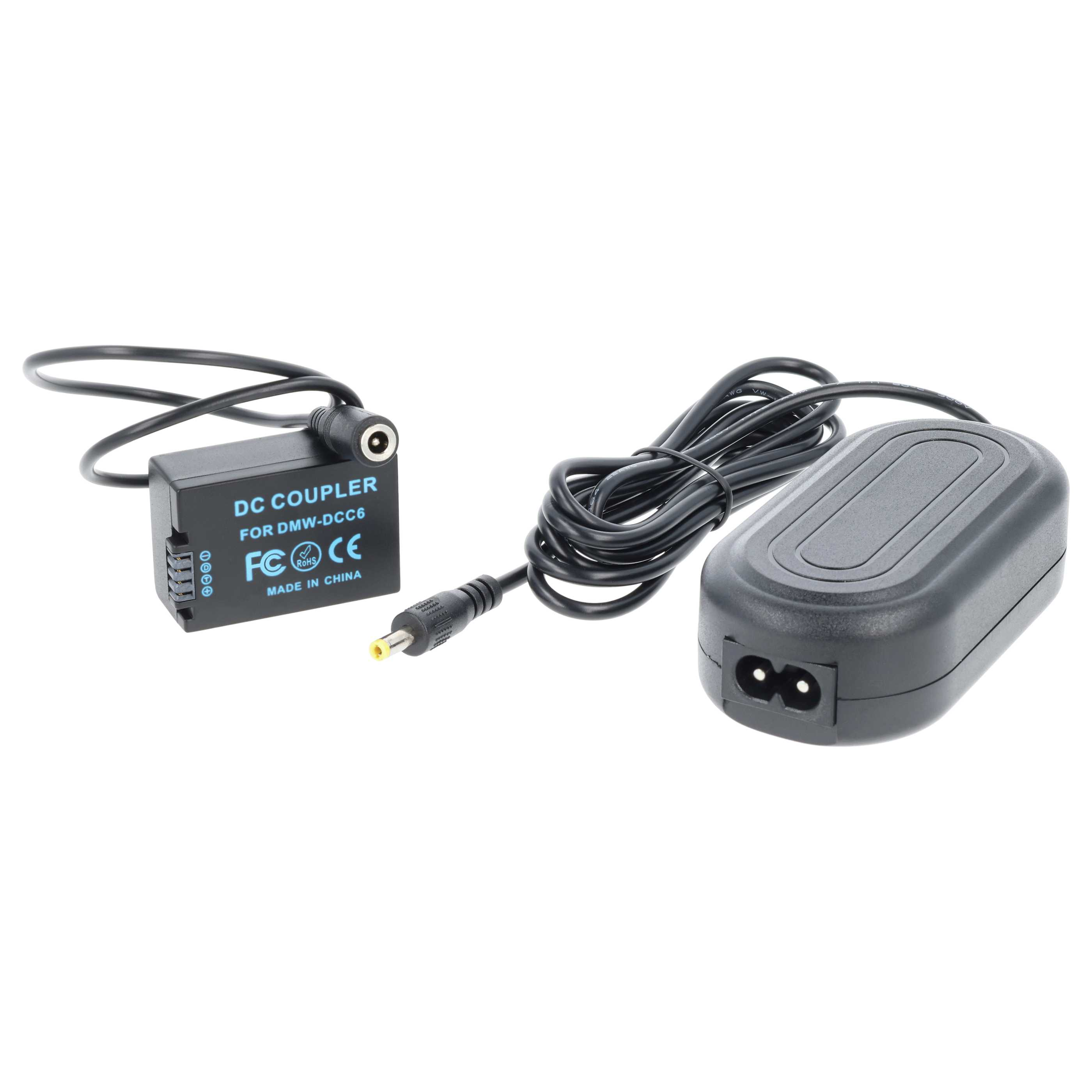 Ein schwarzer DC-Koppler und Netzadapter mit Kabeln auf weißem Hintergrund. Der Koppler hat Text und einen Anschluss.
