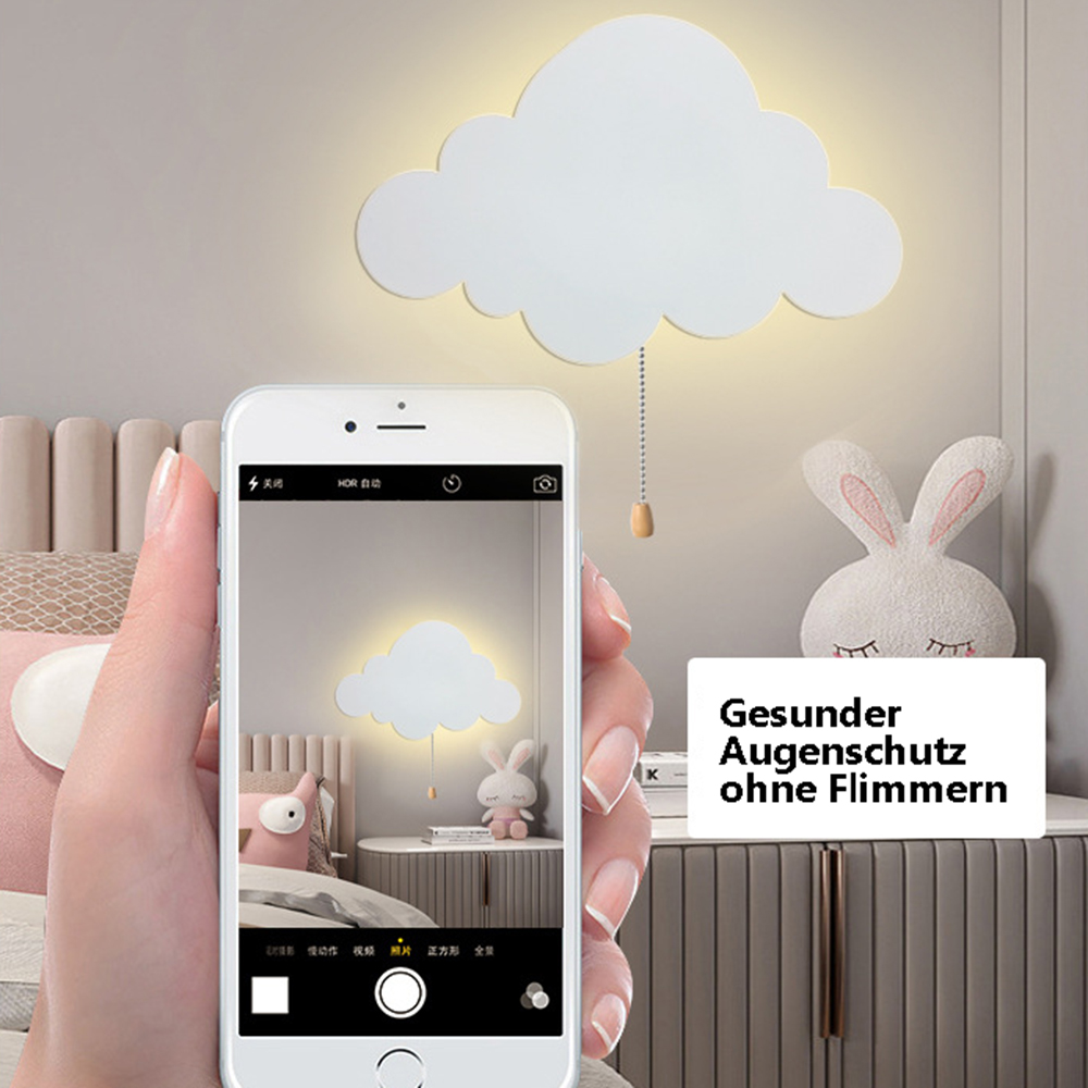 Eine Person hält ein Telefon, das ein Foto einer wolkenförmigen Lampe an der Wand macht. Ein Spielzeugkaninchen steht neben einem Schrank.