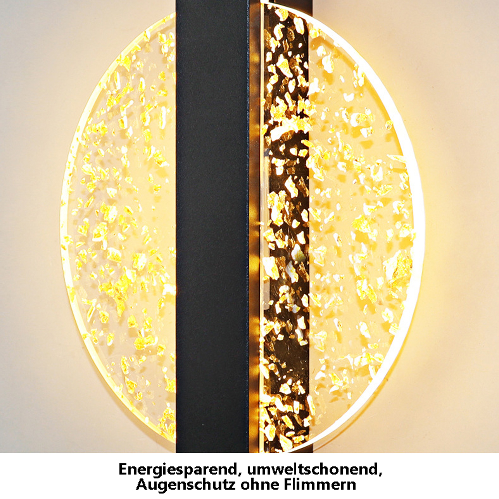 Eine kreisförmige Leuchte mit Blattgold-Design und einem schwarzen vertikalen Streifen. Der Hintergrund ist warmbeige.