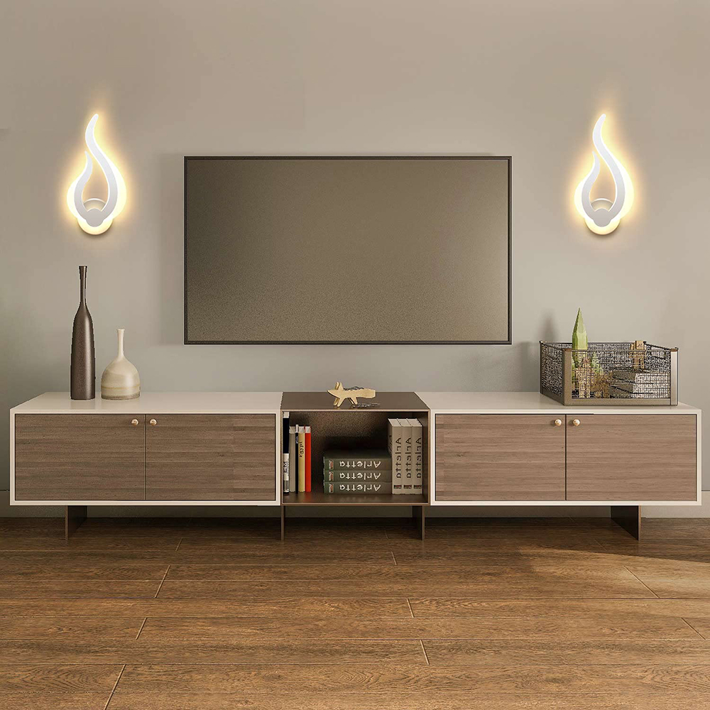 Wohnzimmer mit TV, modernem Schrank, dekorativen Lichtern, Vasen, Büchern und einem Drahtkorb mit Pflanzen. Holzfußboden.