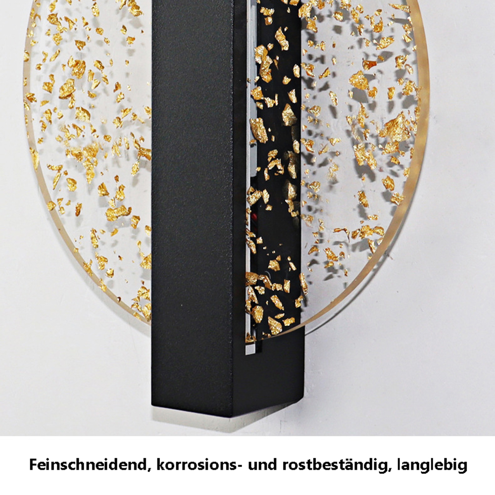 Ein modernes Wandkunstwerk. Es hat ein klares, kreisförmiges Design mit Goldblattakzenten. Schwarzer Rahmen. Weißer Wandhintergrund.