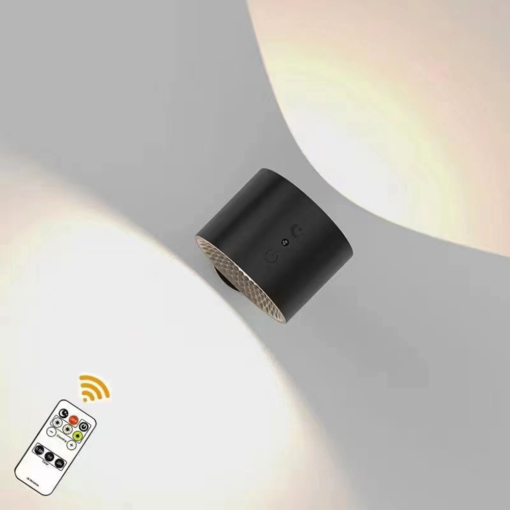 Schwarze zylindrische Lampe mit Fernbedienung. Die Lampe hat einen goldfarbenen Boden und steht auf weißem Untergrund.