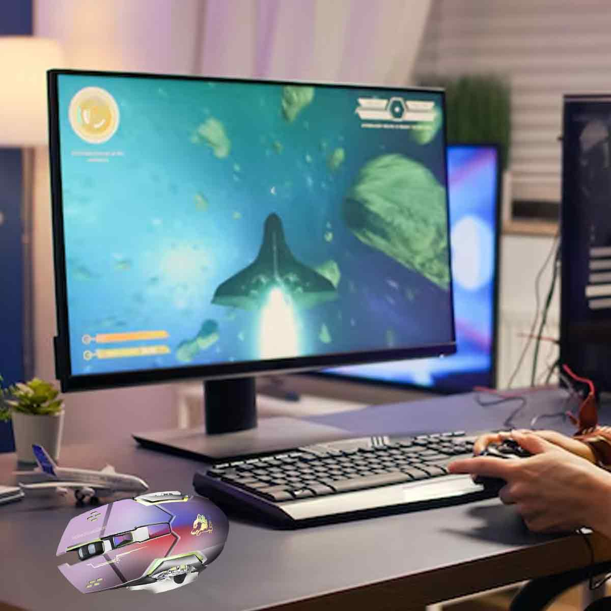 Eine Person spielt ein Spiel am Computer. Der Bildschirm zeigt ein Raumschiff im Weltraum. Maus und Tastatur sind davor.