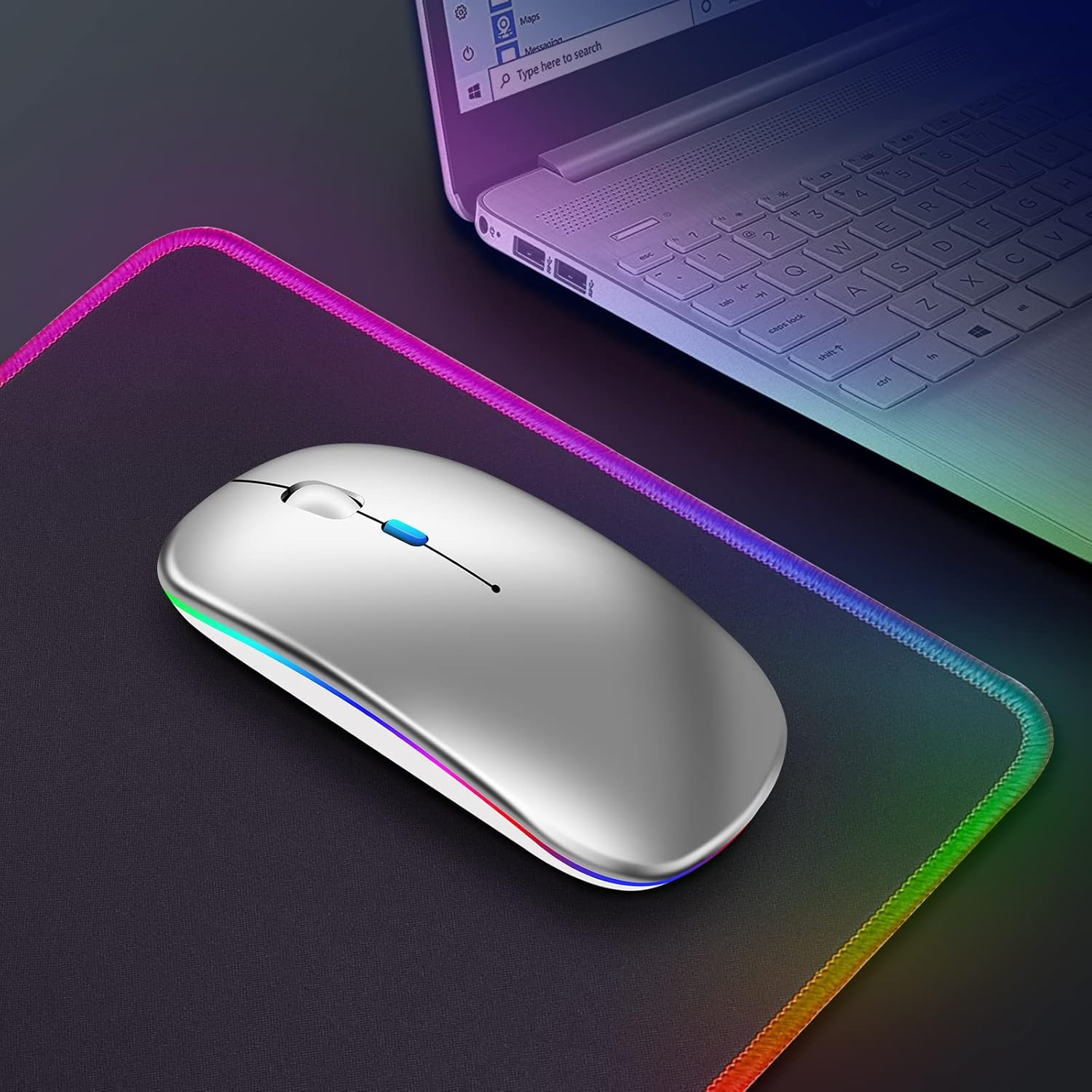 Eine silberne kabellose Maus mit einem Laptop im Hintergrund. Die Maus liegt auf einem Pad mit bunten Rändern.